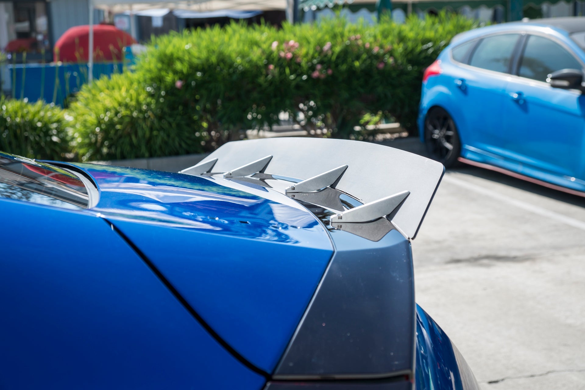 Close-up angle of the spoiler extension teeth on a blue Civic non-Si Coupe
