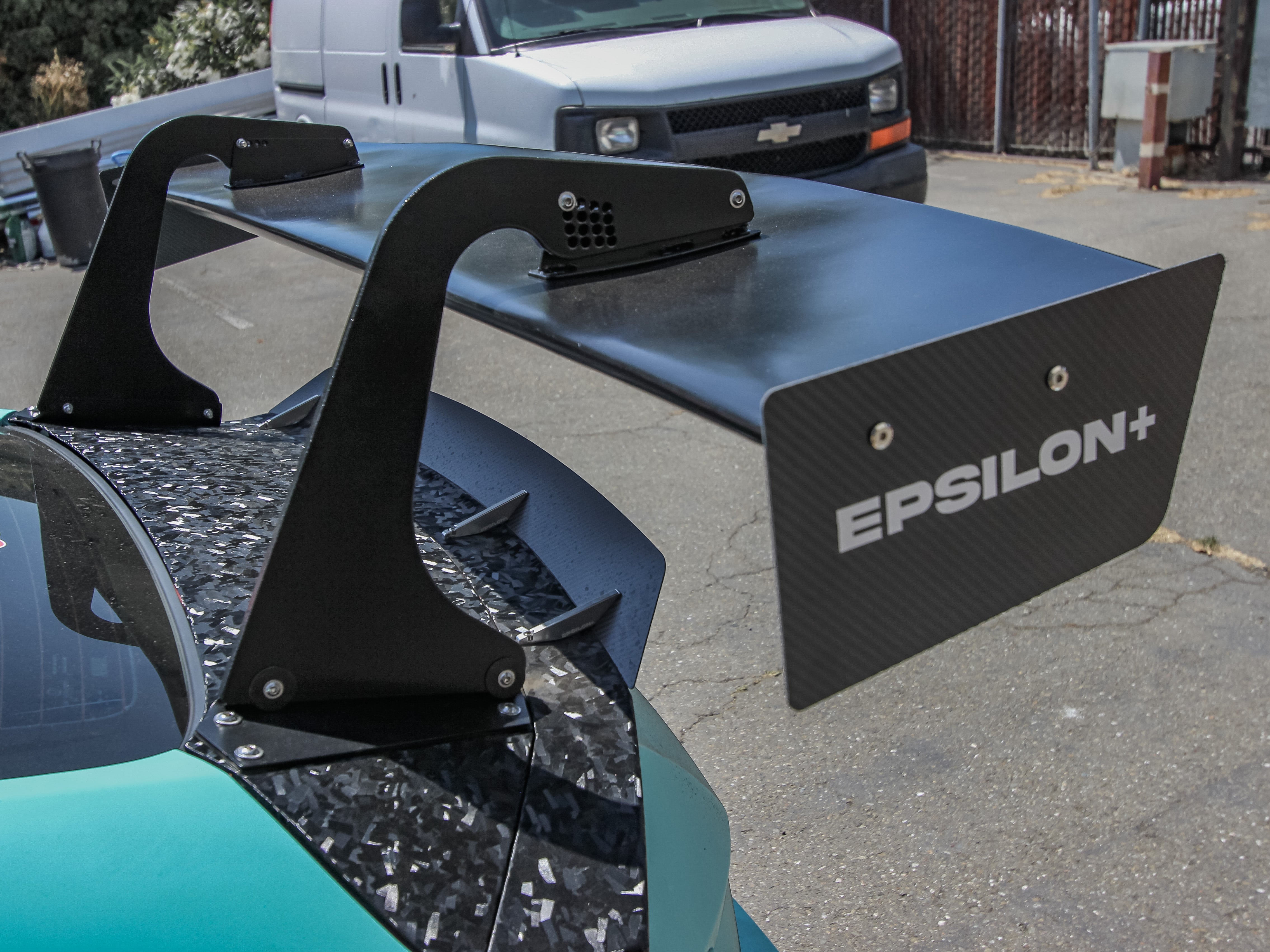 Close-up of the Epsilon+ GT wing swan mount on a teal Civic Si Coupe