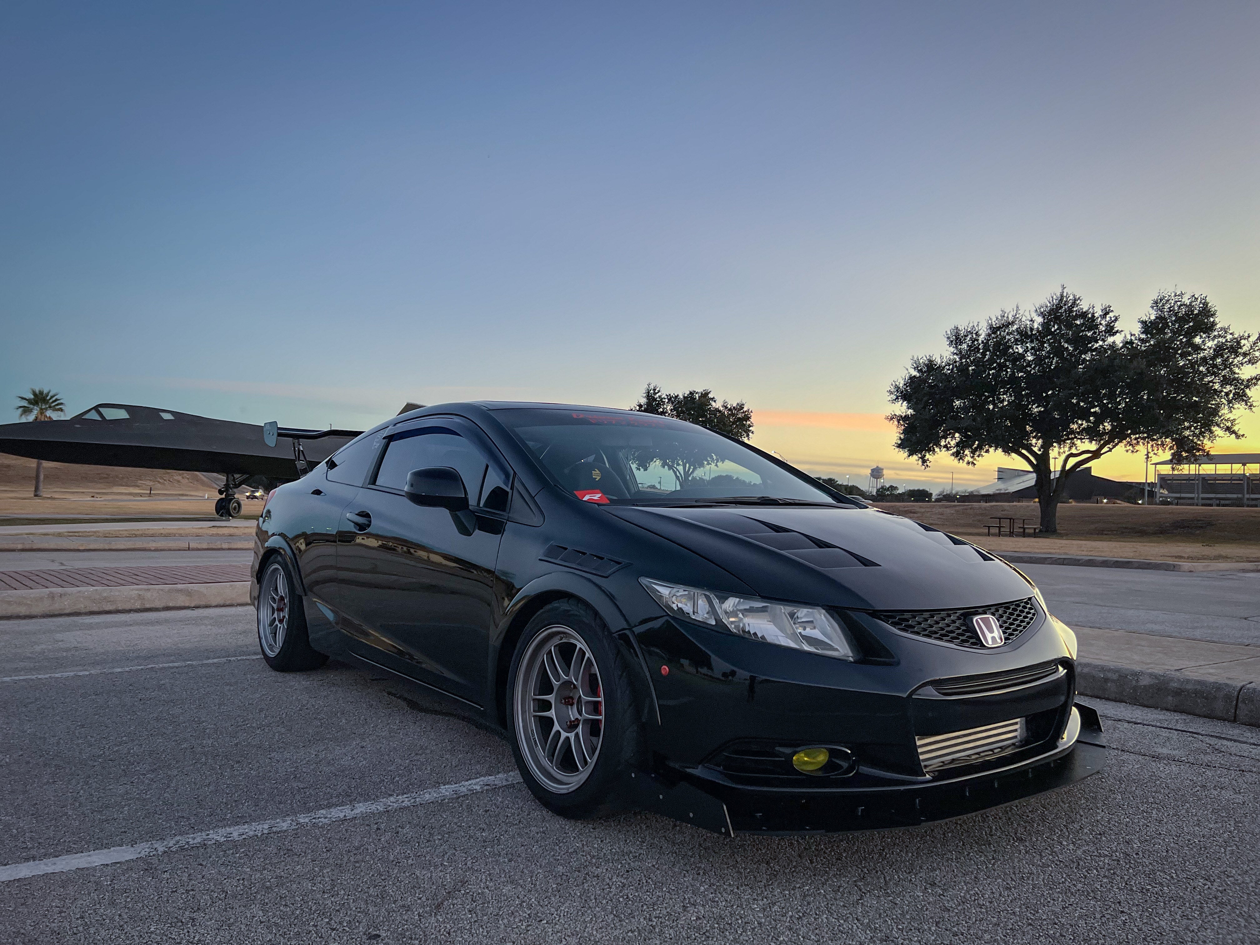 Front three-quarter view of a black Civic Si Coupe Zenki with front splitter at sunset