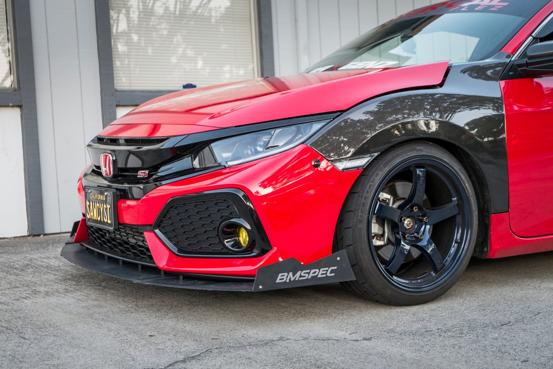 Close-up front view of the front splitter on a red Civic Si Coupe bumper