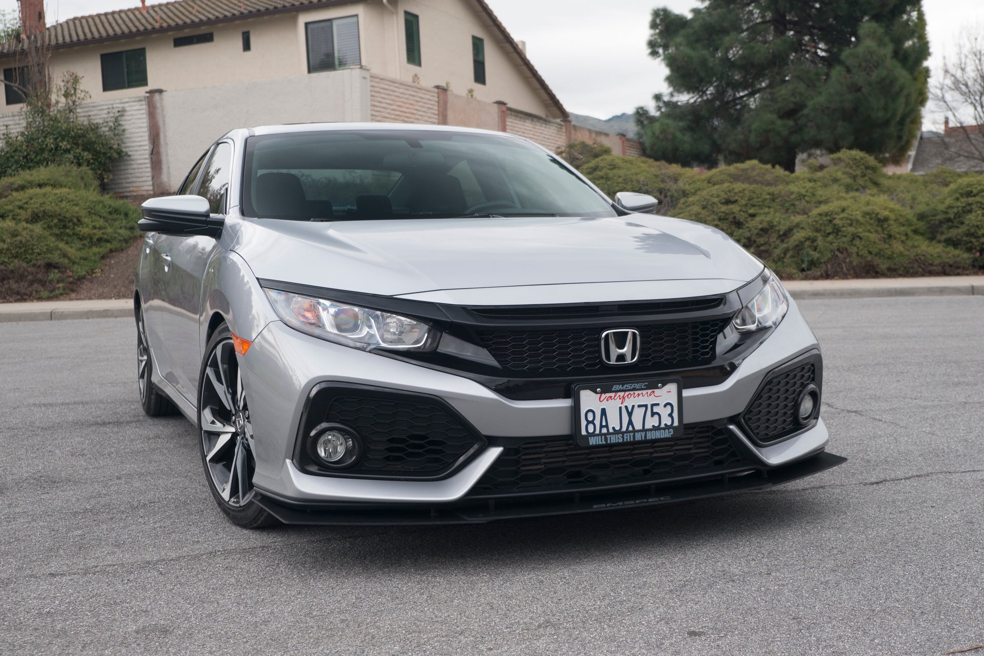 Front three-quarter view of the silver Civic Si with front lip in a residential driveway