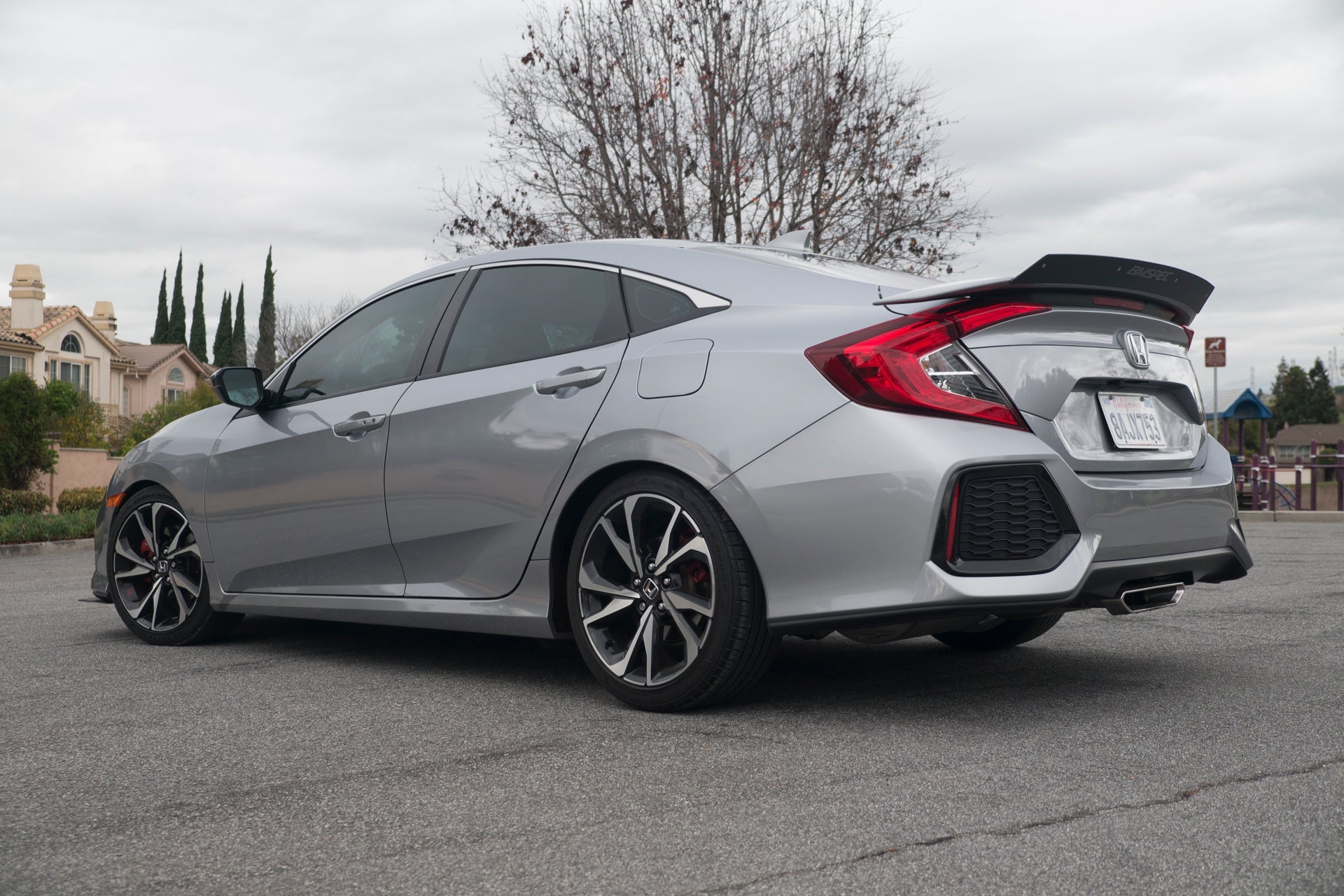 Rear three-quarter view of a silver Civic Si Sedan with Epsilon+ spoiler extension