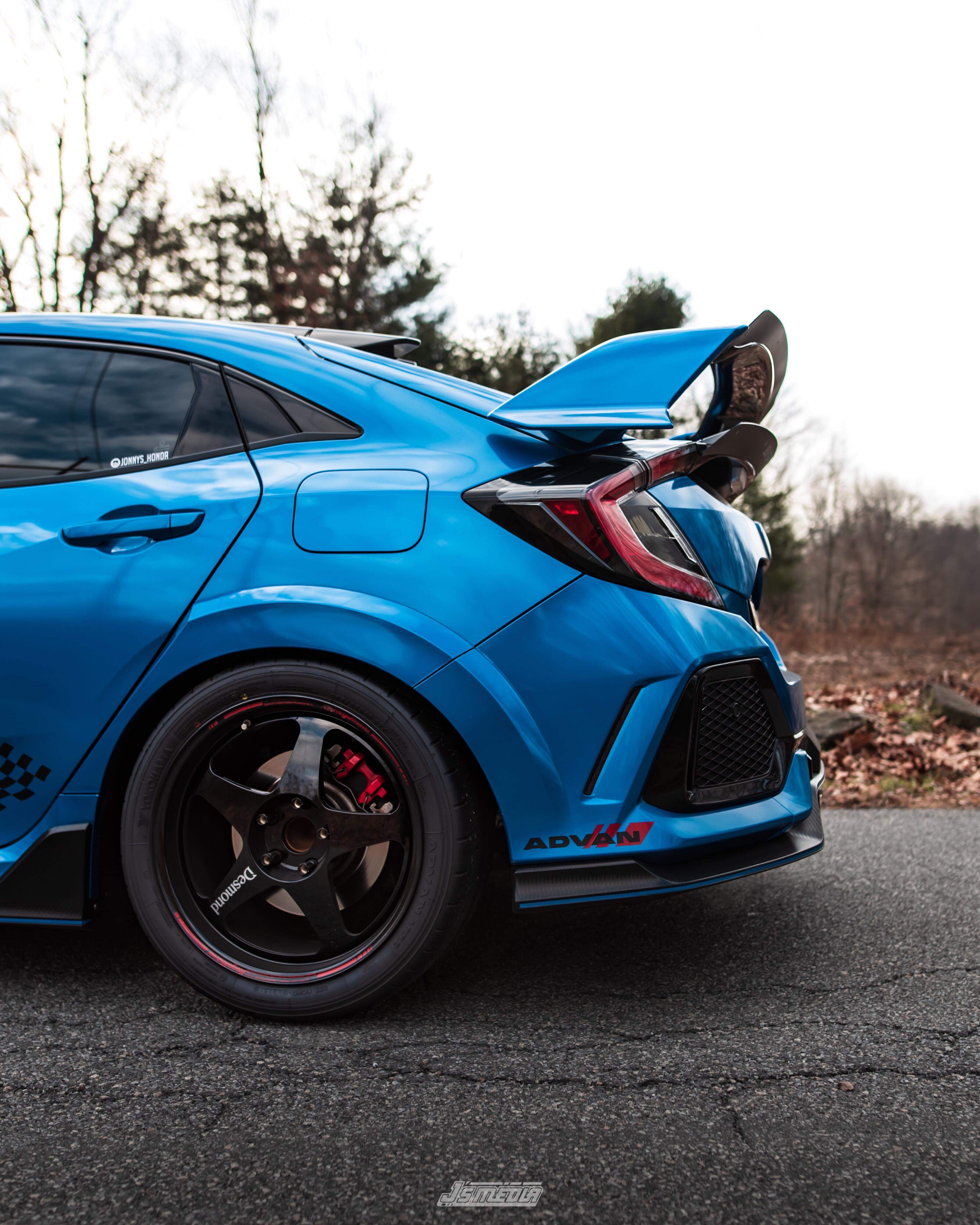 Rear three-quarter view of a blue Civic Type R FK8 with double spoiler extension