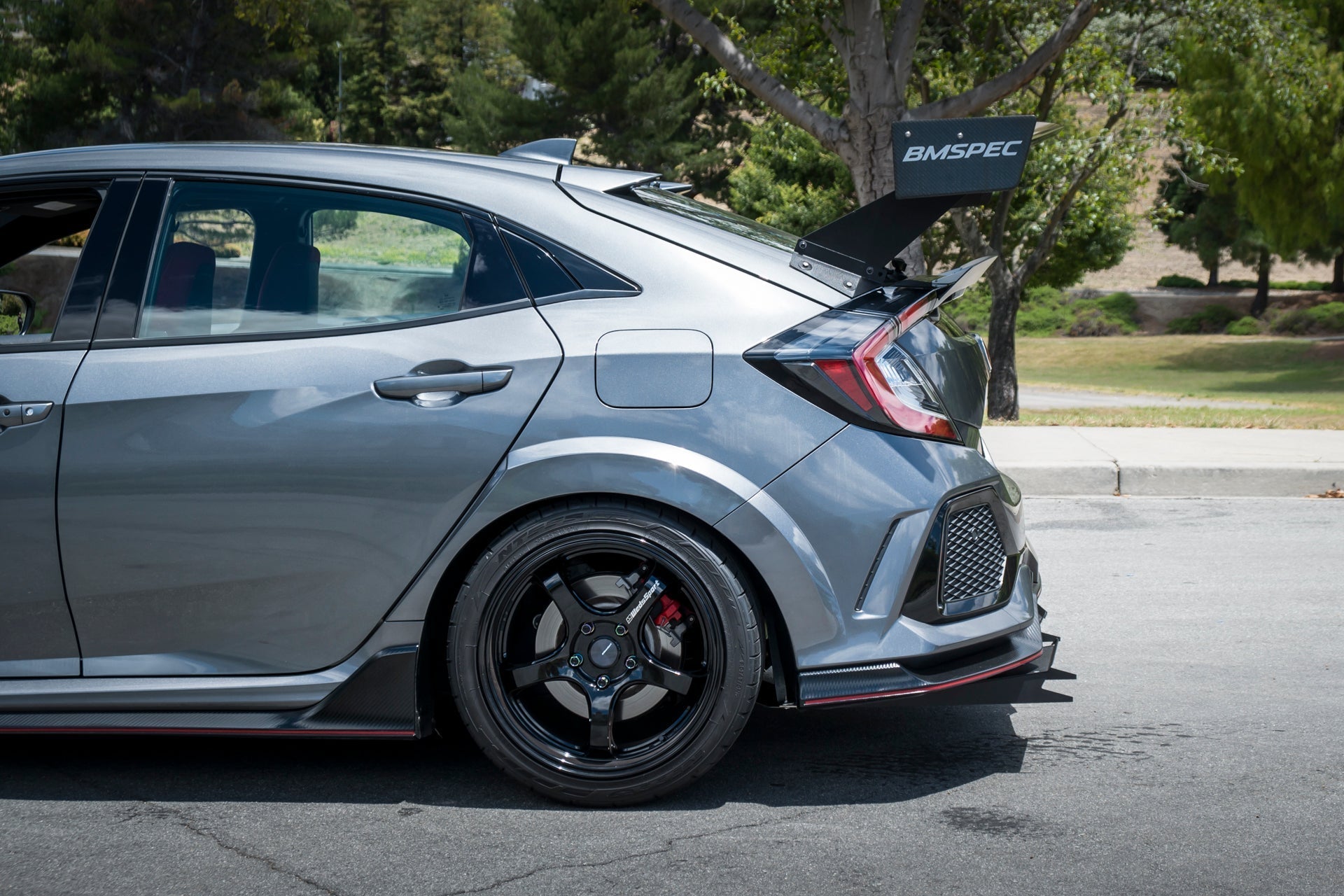 Side profile of gray Civic Type R with carbon GT wing and adjustable risers