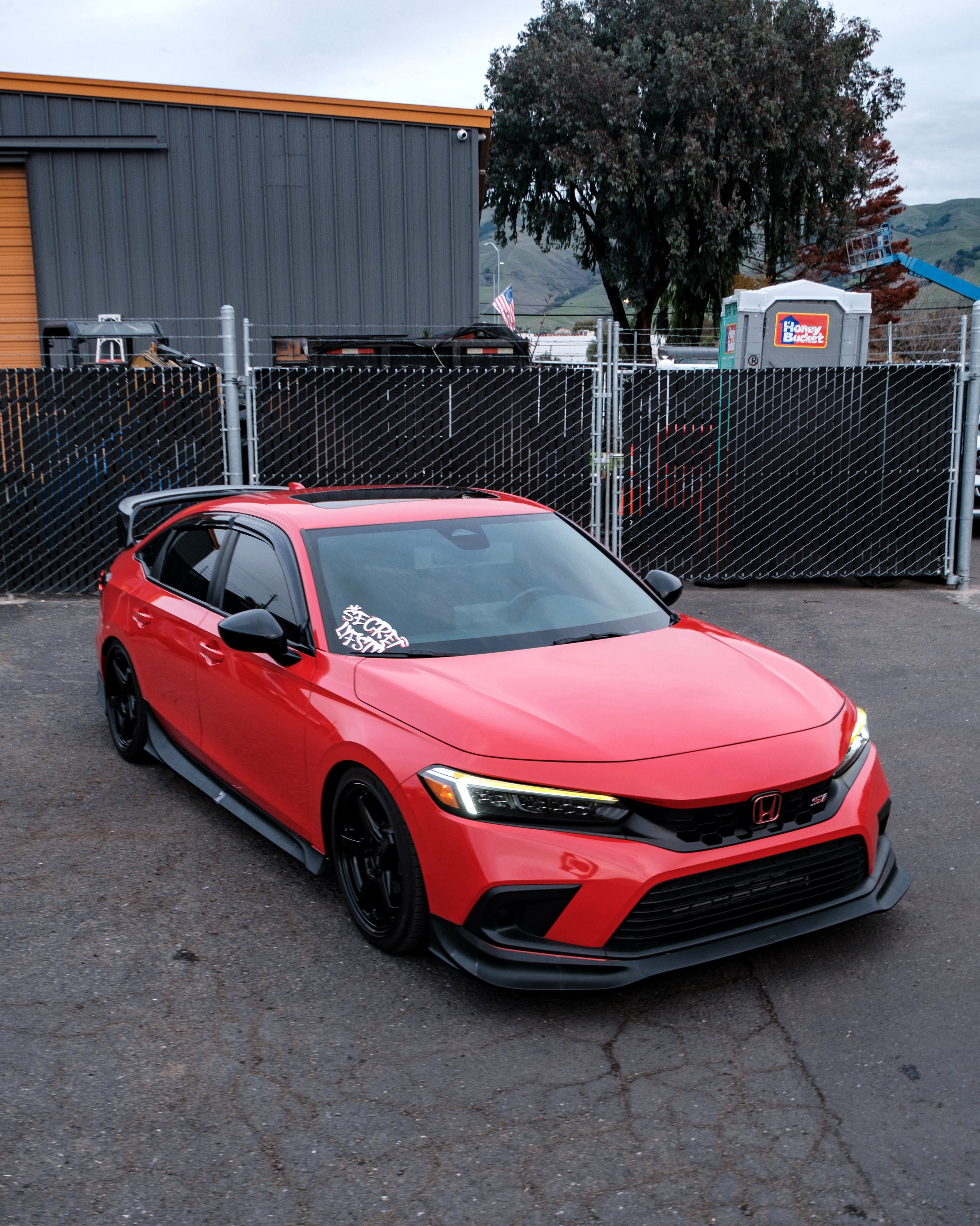 Side-front view of a red Honda Civic with the Epsilon+ front lip