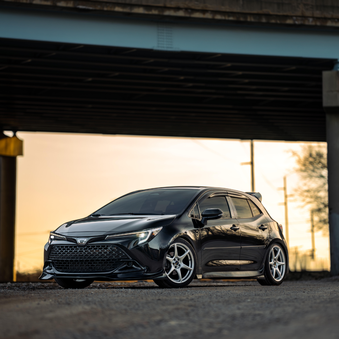 Black Toyota Corolla Hatchback with the Epsilon+ aero kit under a carport at sunset