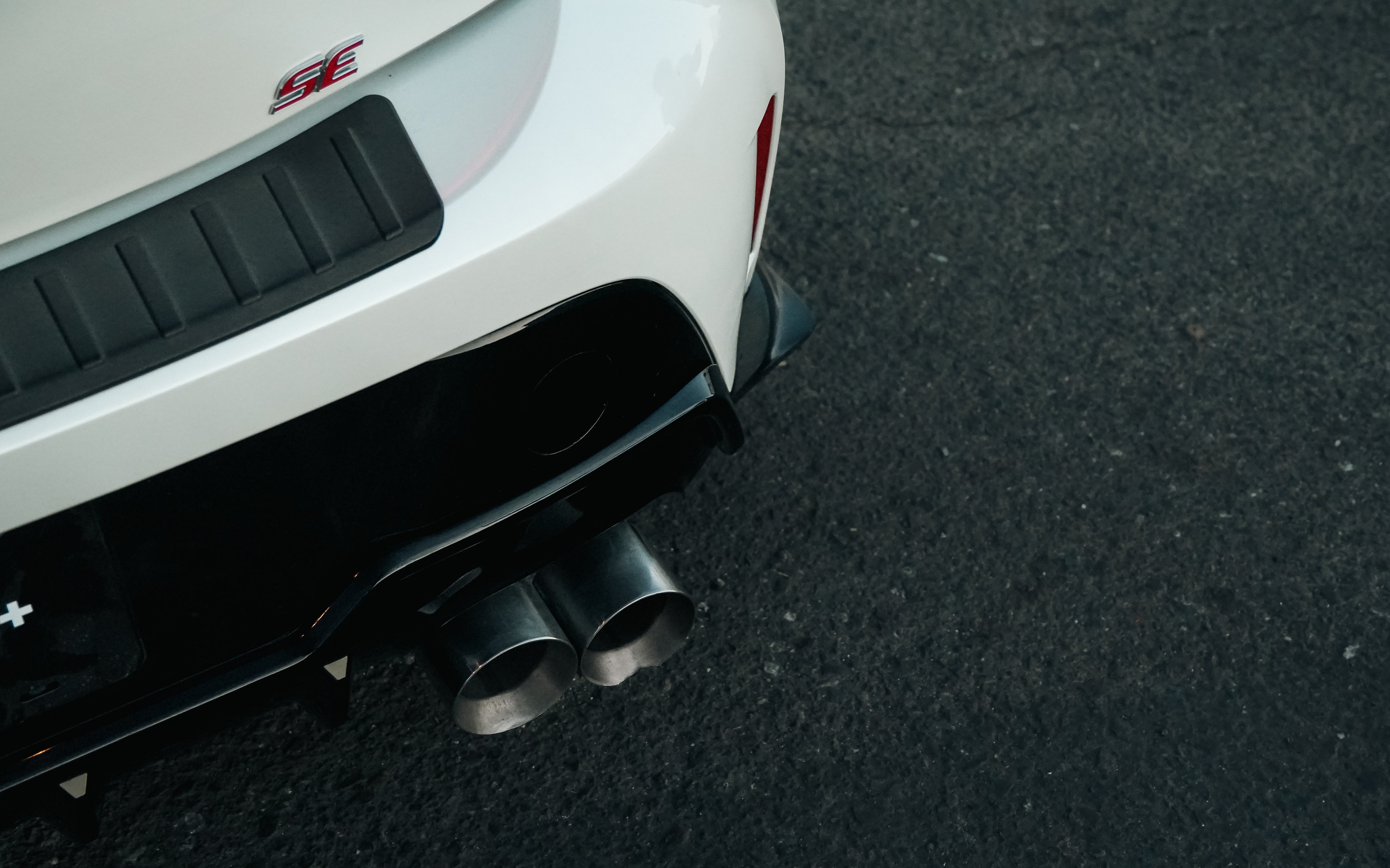 Close-up of the rear spats and exhaust on a white Toyota Corolla Hatchback