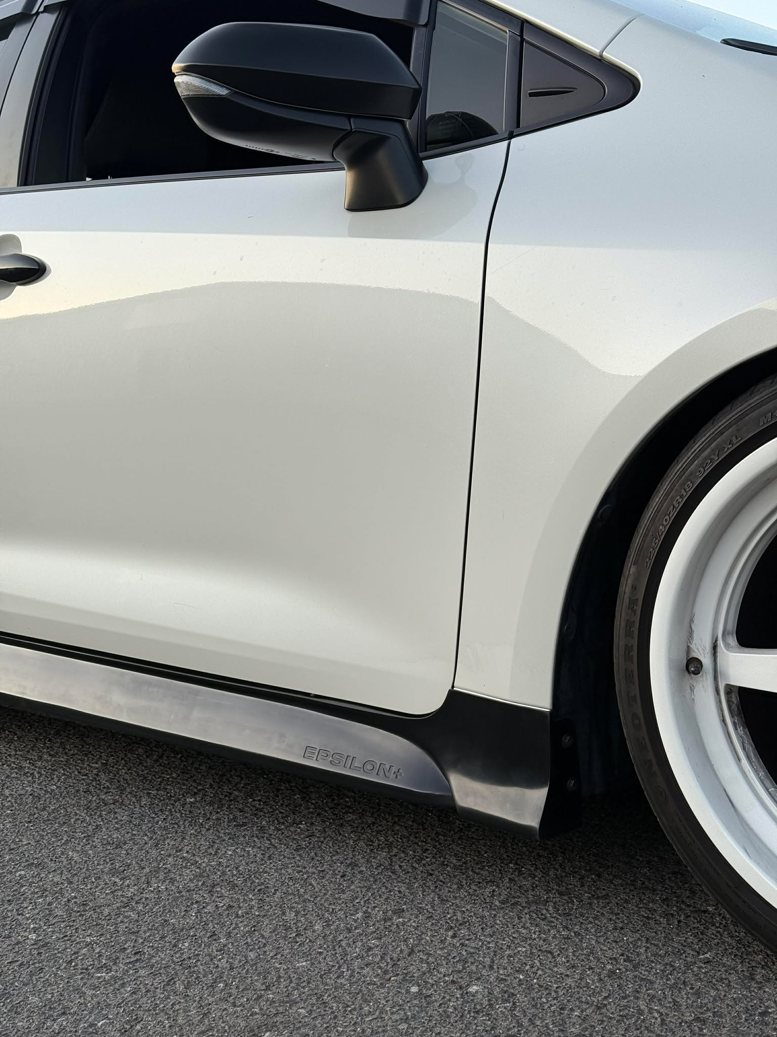 Close-up of the Epsilon+ side skirt along the rocker of a white Corolla Hatchback