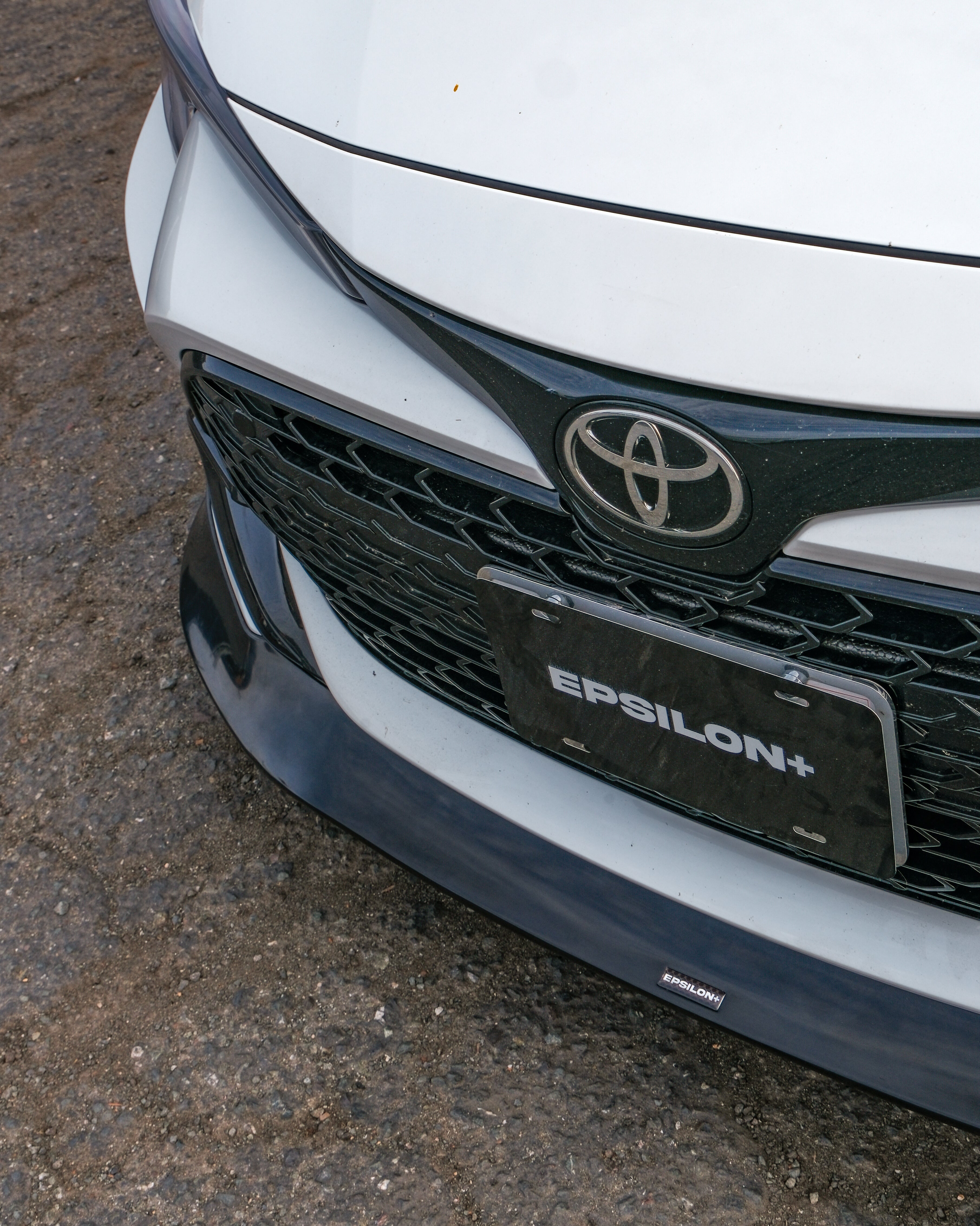 Close-up of the Epsilon+ front lip and badge on a white Corolla Hatchback Kouki
