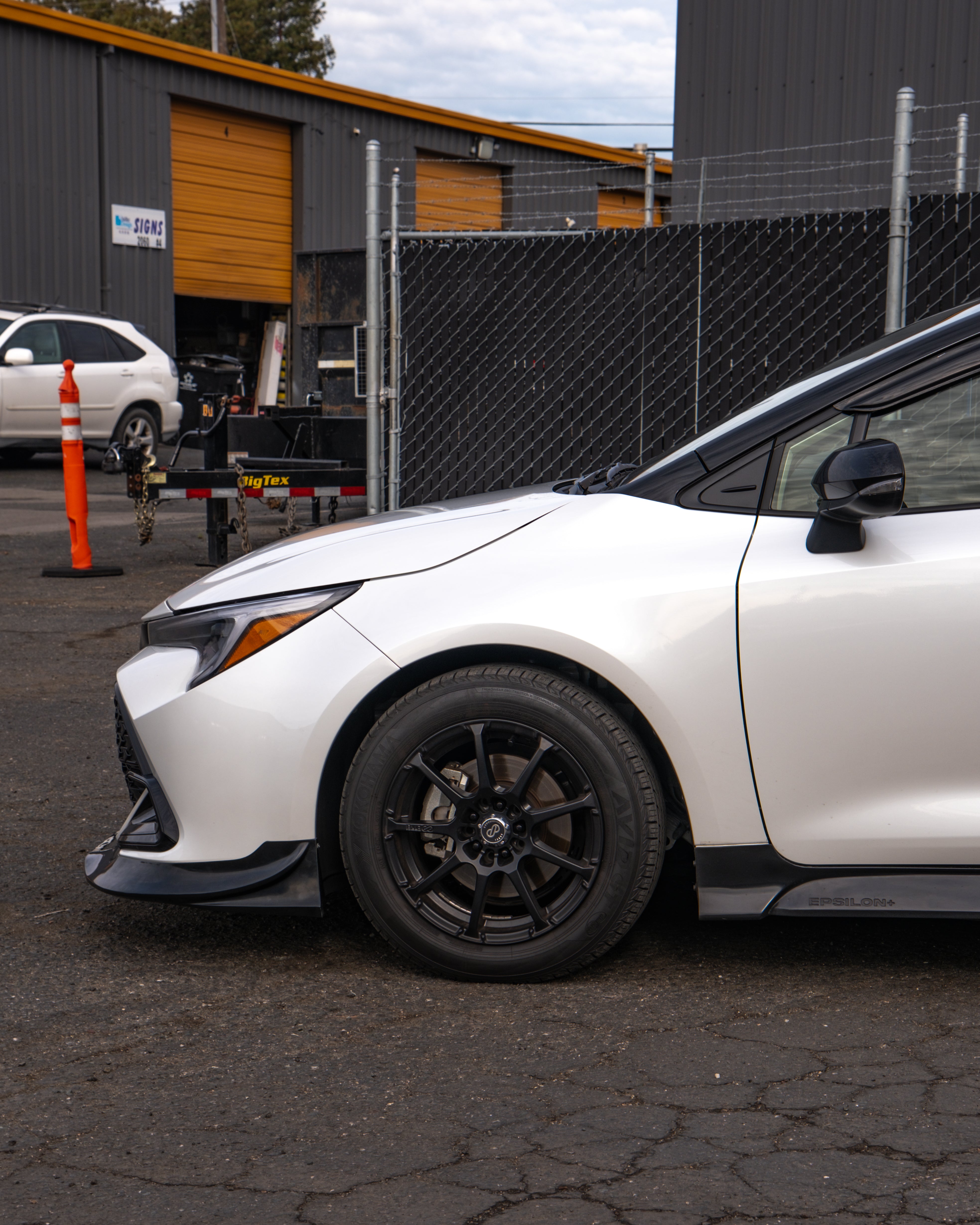 Low front three-quarter view of a white Corolla Hatchback Kouki with front lip