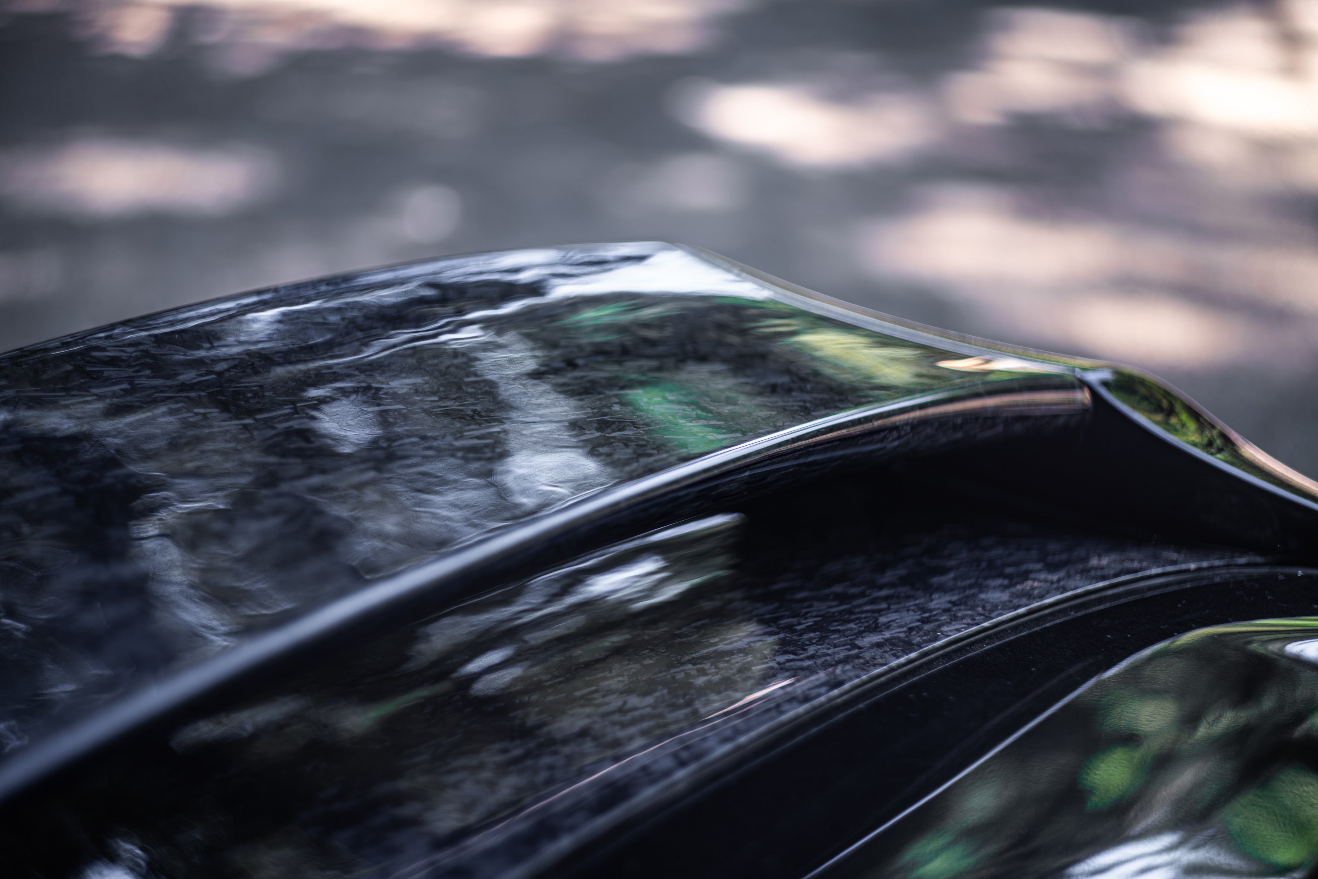 Close-up rear view of the WRC Wing V3 on a black Corolla Hatchback at dusk