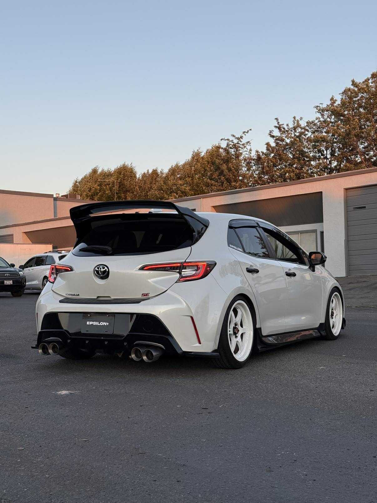 Rear three-quarter view of a white Corolla Hatchback with WRC Wing V3 outdoors