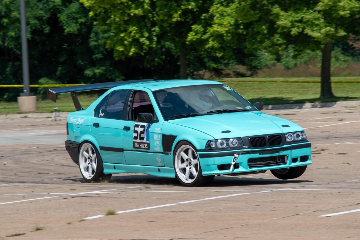 TC Wing on a teal BMW E36 autocrossing, front three-quarter action shot