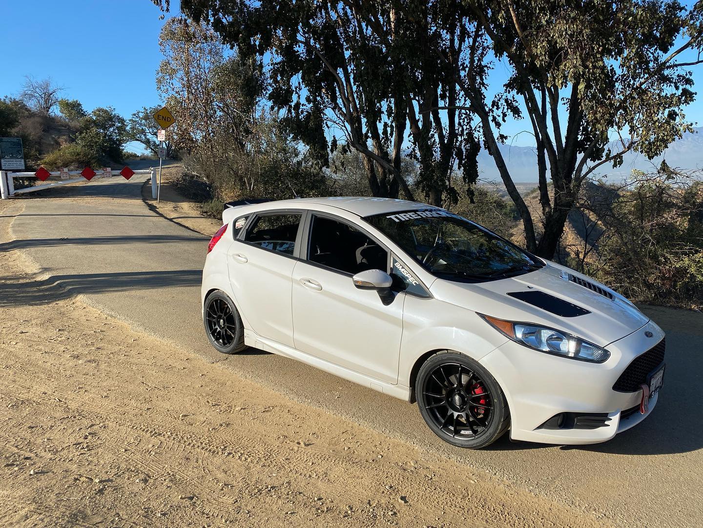 White Fiesta ST with spoiler extension parked on a dirt overlook