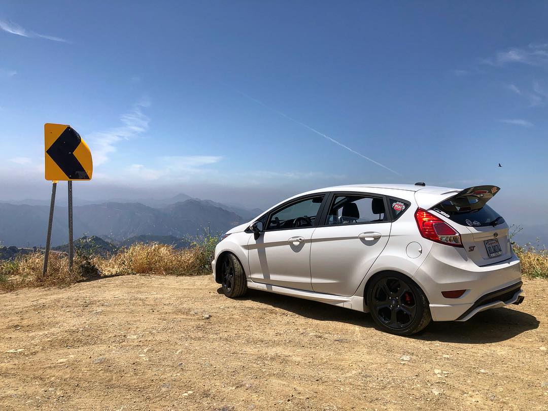 White Fiesta ST with spoiler extension parked on a mountain overlook