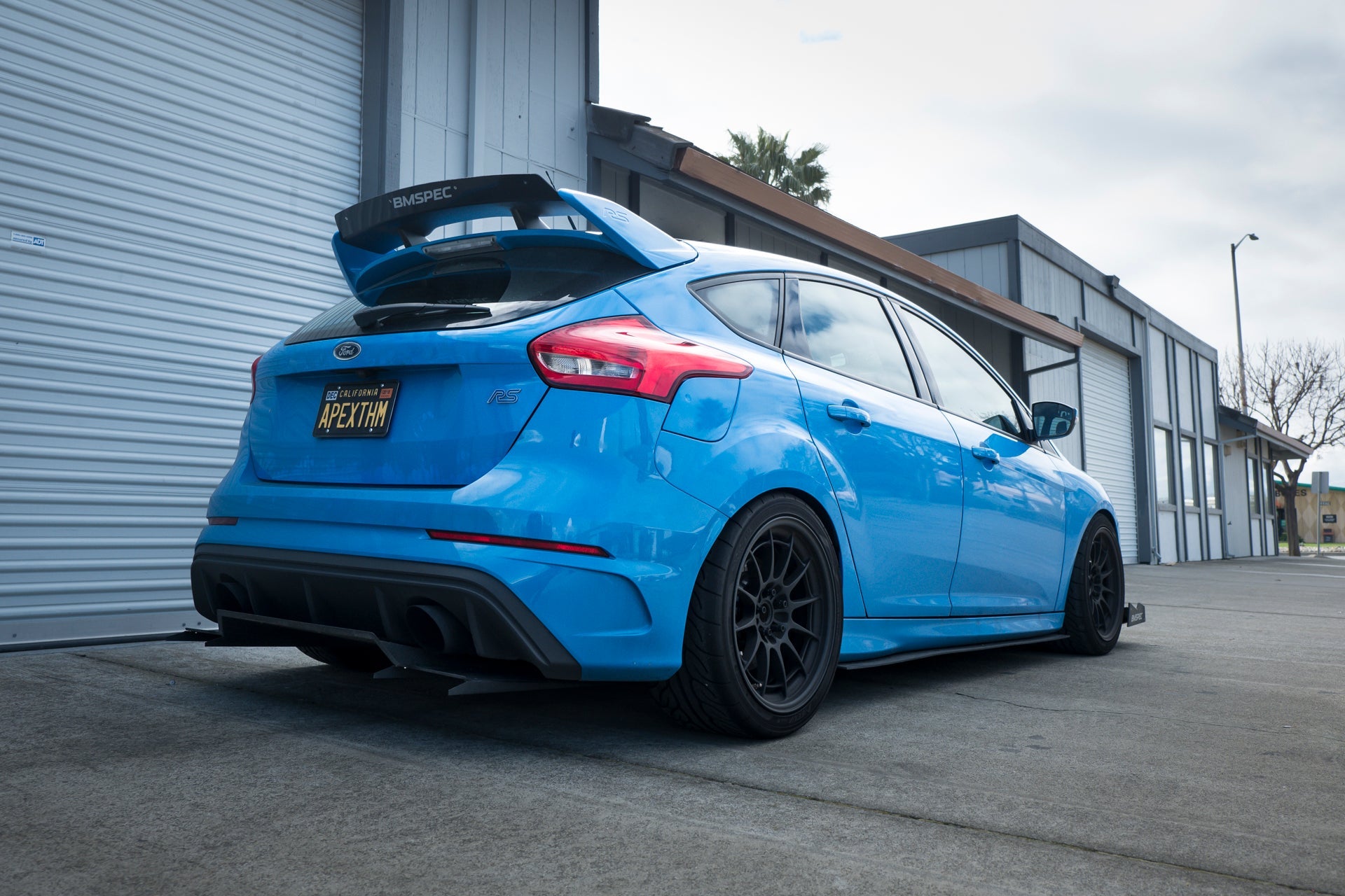 Rear three-quarter view of a blue Ford Focus RS with Epsilon+ spoiler extension