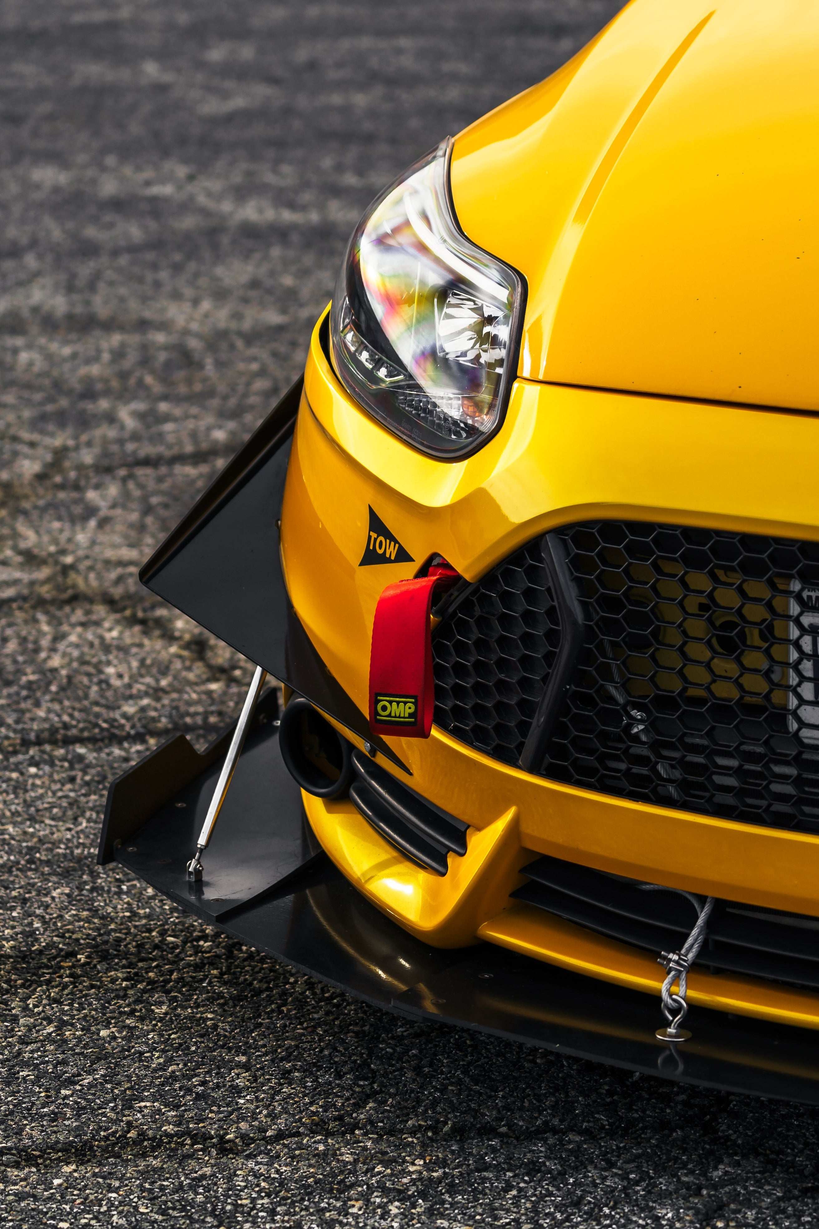 Close-up of the front splitter on a yellow Ford Focus ST bumper