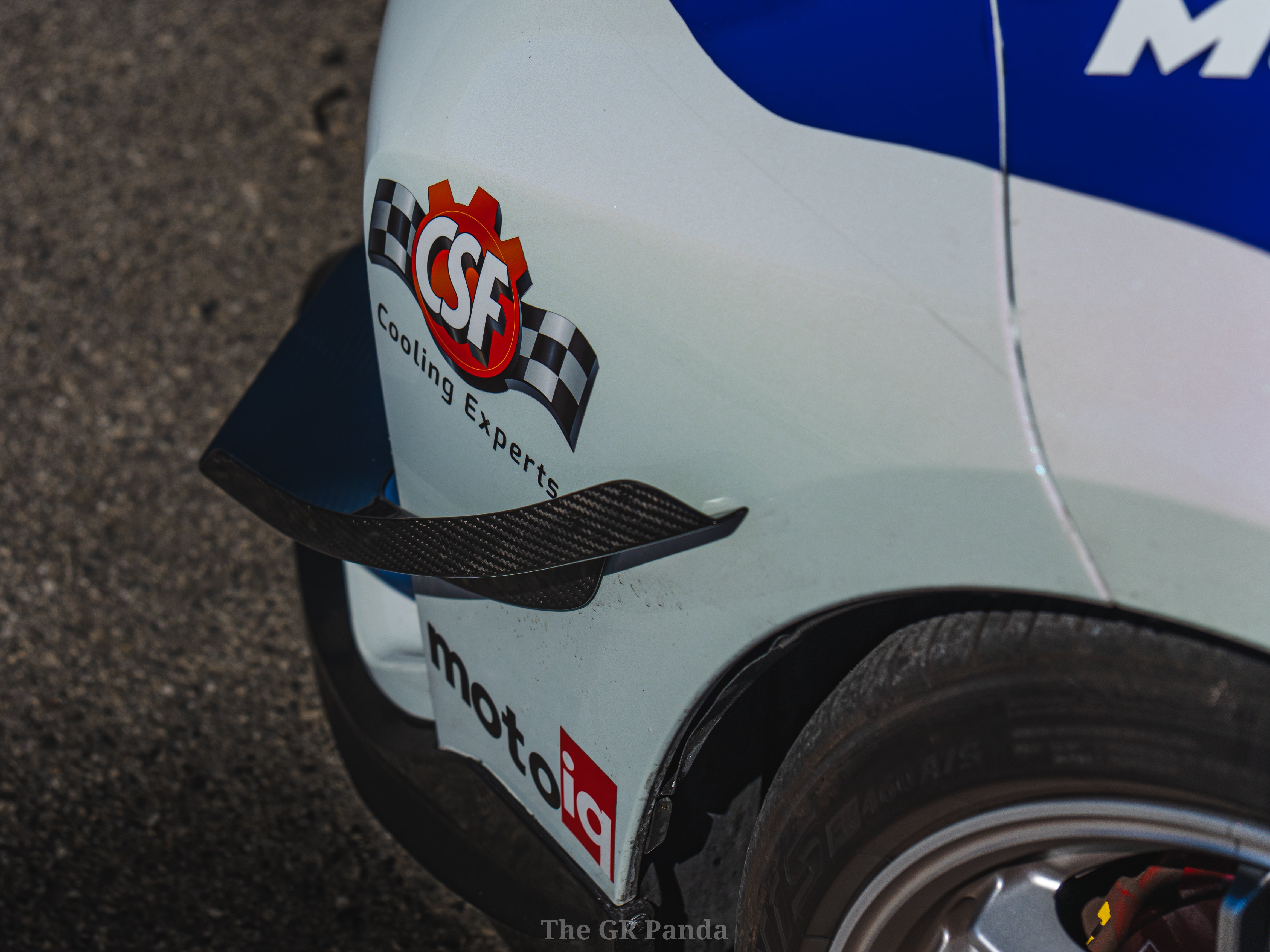 Rear three-quarter close-up of a canard on a white GR Corolla rally car