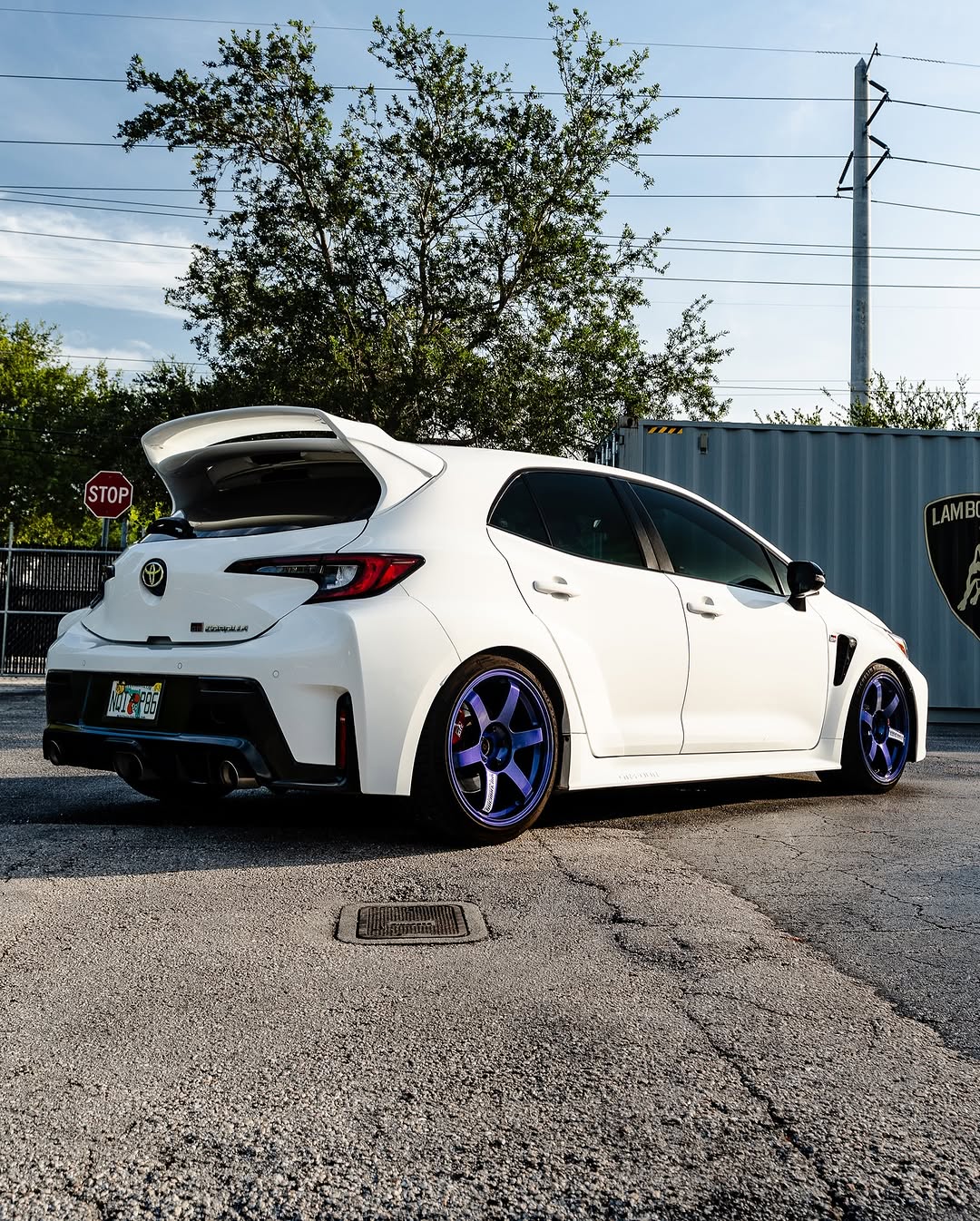 Rear three-quarter view of a white GR Corolla with WRC Wing V3 on the street