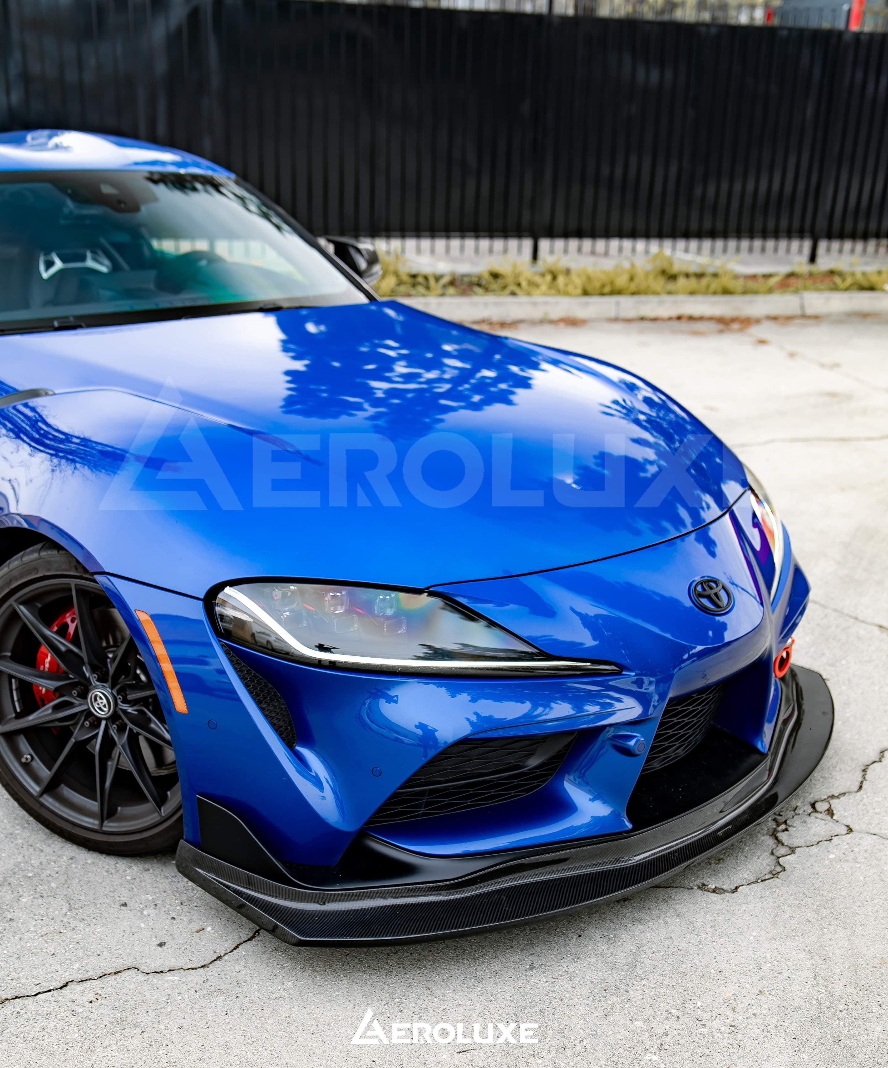 Close front corner view of the GT4-spec front lip on a blue Toyota GR Supra