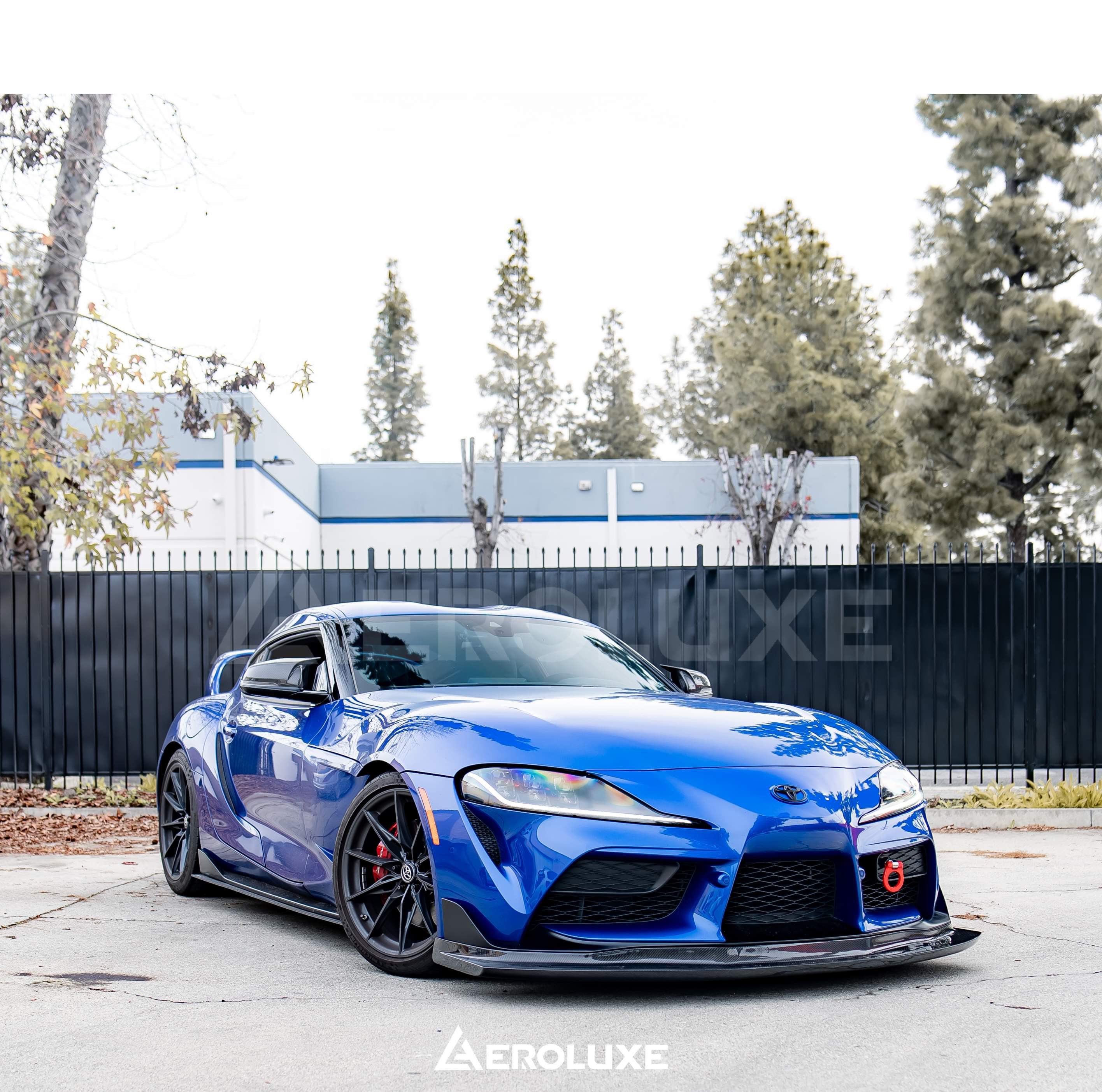 Front three-quarter view of a blue GR Supra with GT4-spec front lip and splitter