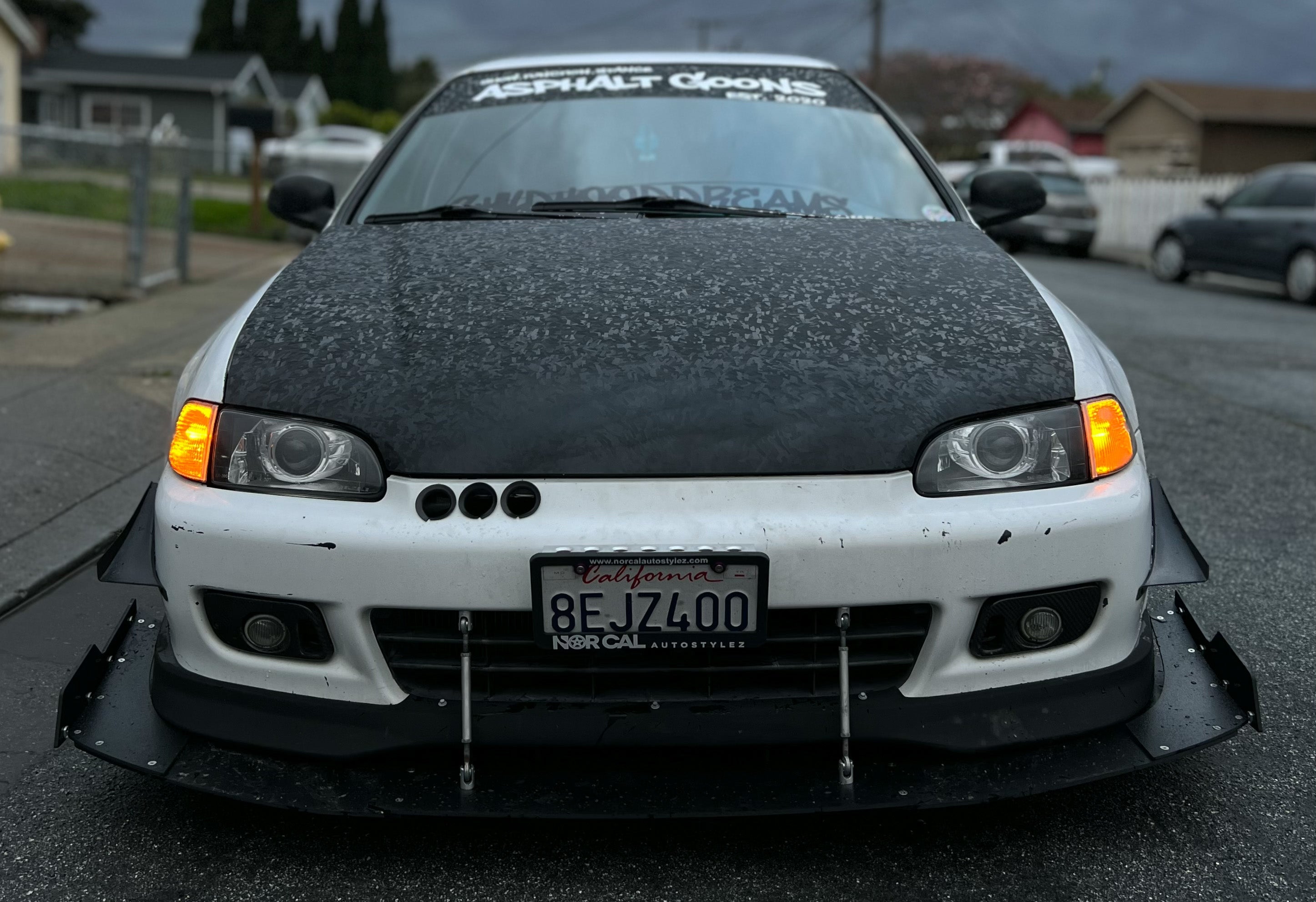 Front-on view of a white Honda Civic EG with front splitter and carbon hood wrap