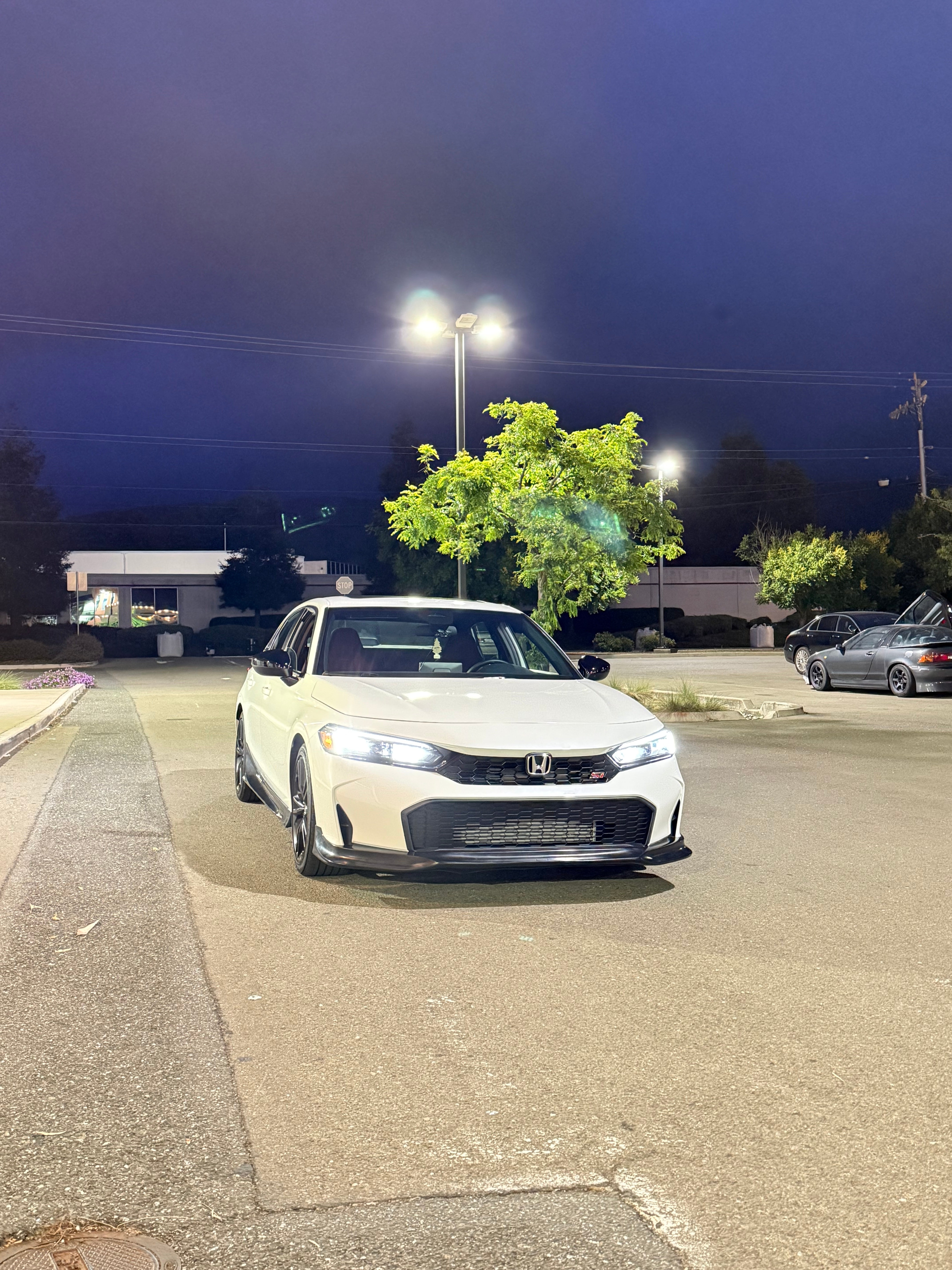 White Honda Civic with the Epsilon+ front lip parked at dusk