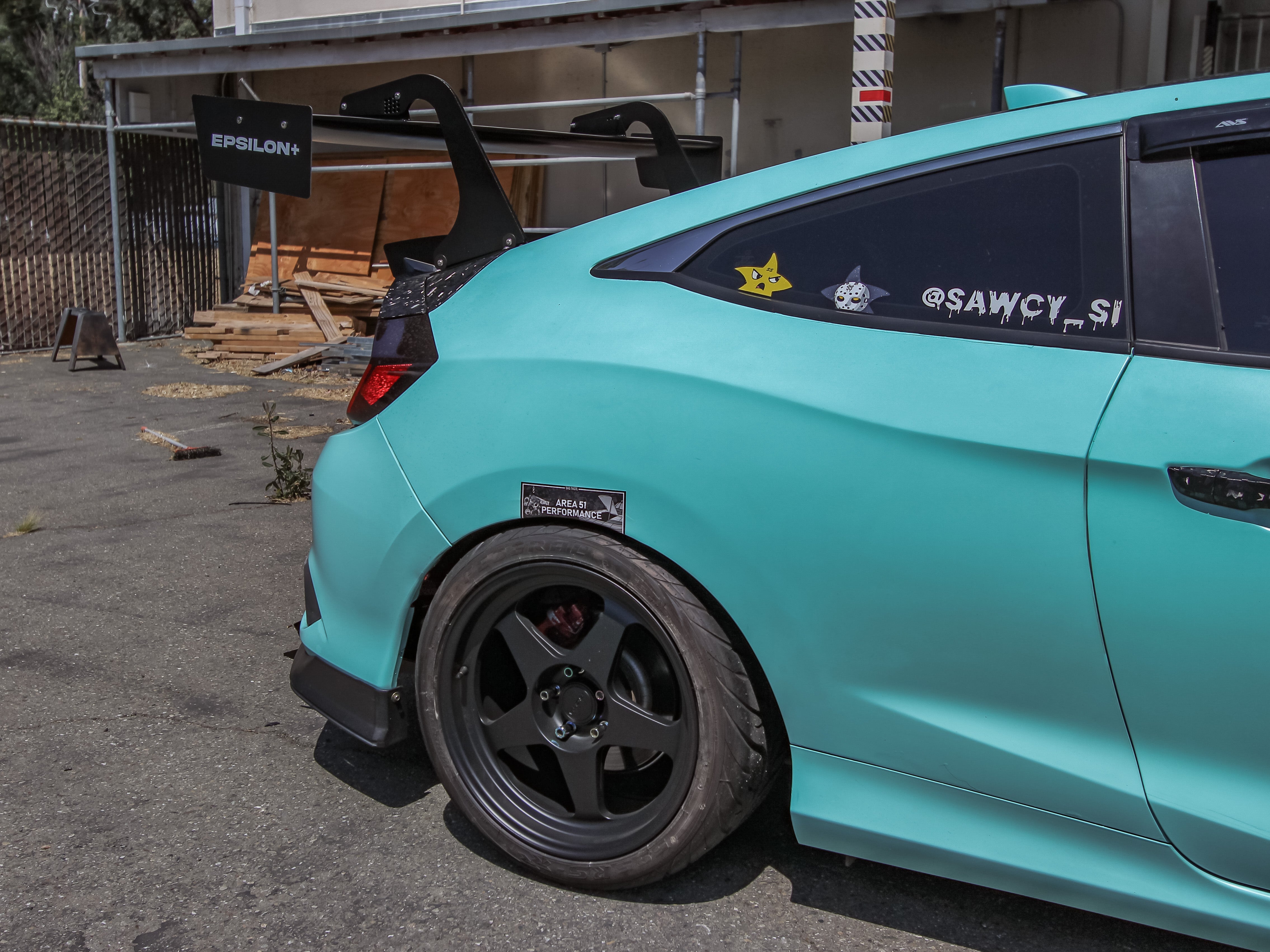Rear three-quarter view of a teal Civic Si Coupe FC3 with GT wing