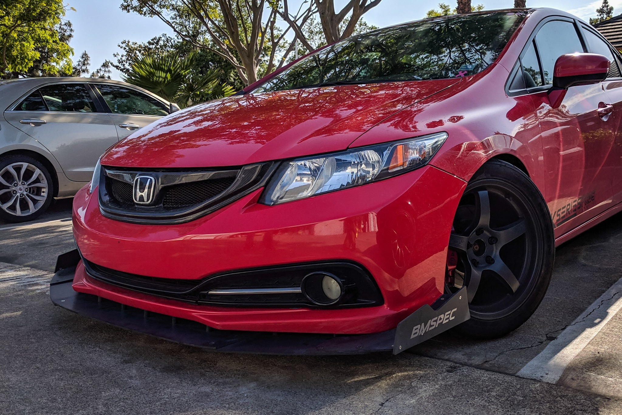 Front three-quarter view of a red Civic Si Sedan FB6 Kouki with front splitter in a parking lot