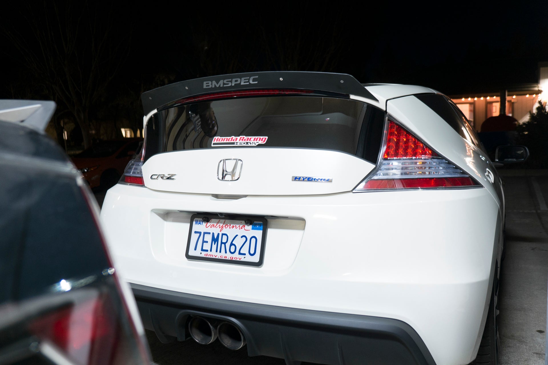Rear view of a white Honda CR-Z with spoiler extension at night