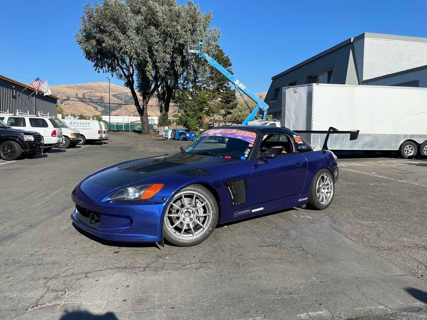Front three-quarter view of a blue Honda S2000 roadster with GT wing