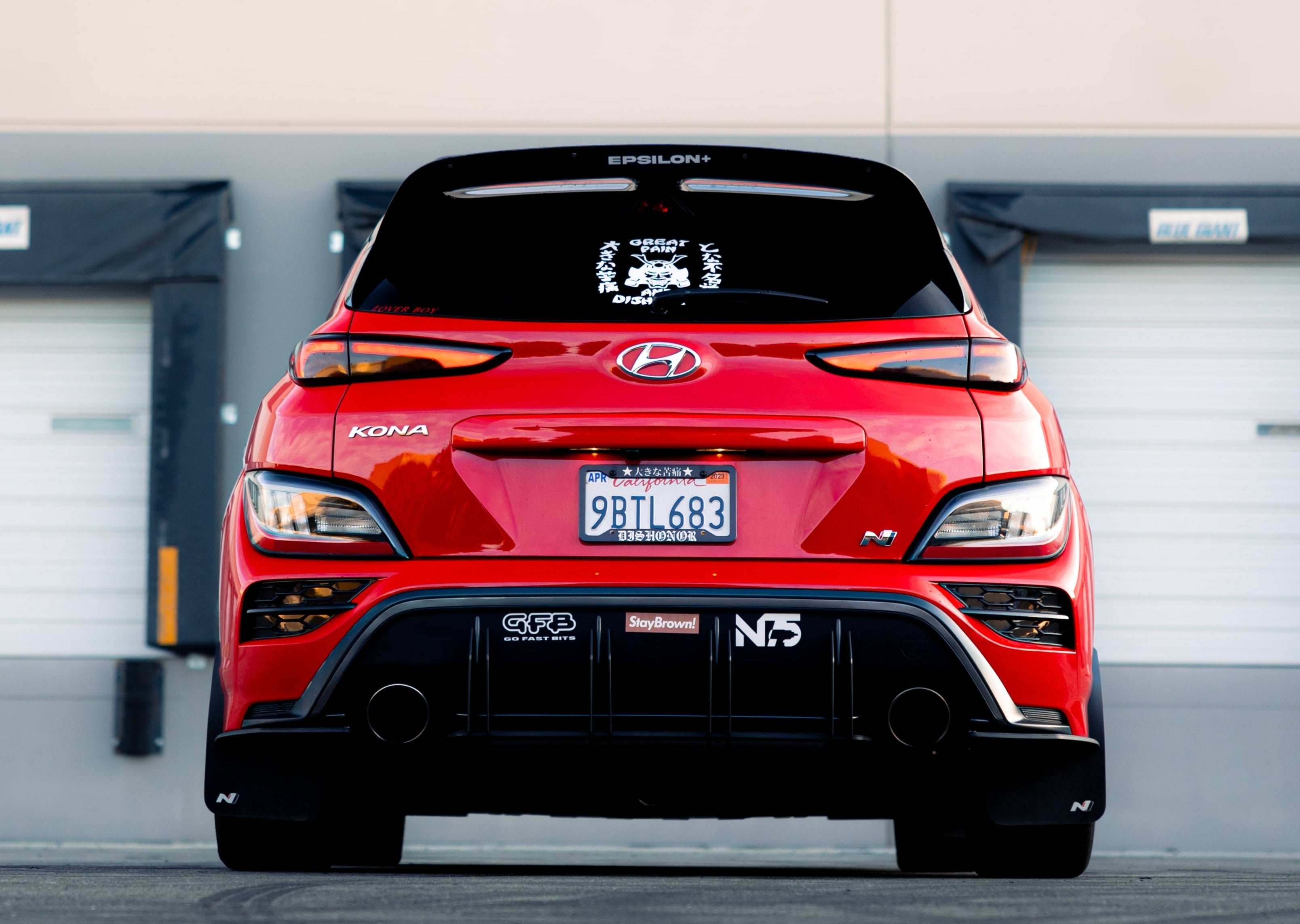 Rear view of a red Kona N showing the spoiler extension and taillights