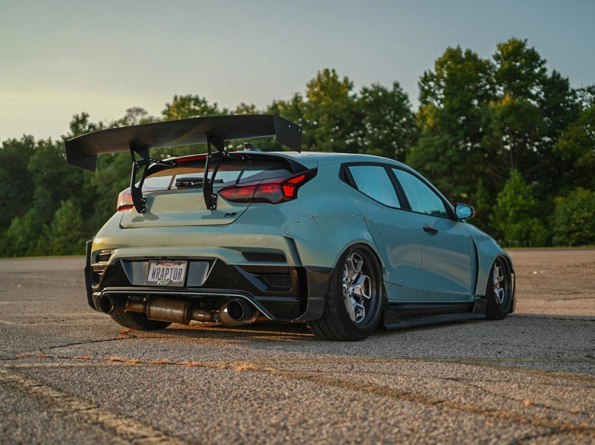 Rear three-quarter view of a mint Hyundai Veloster JS with Epsilon+ GT wing at sunset
