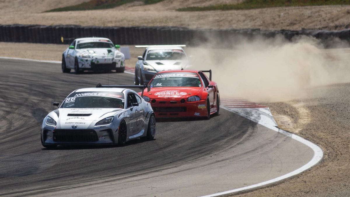 Toyota GR86 ZN8 race cars cornering on track, a white GR86 with a rear wing in the lead