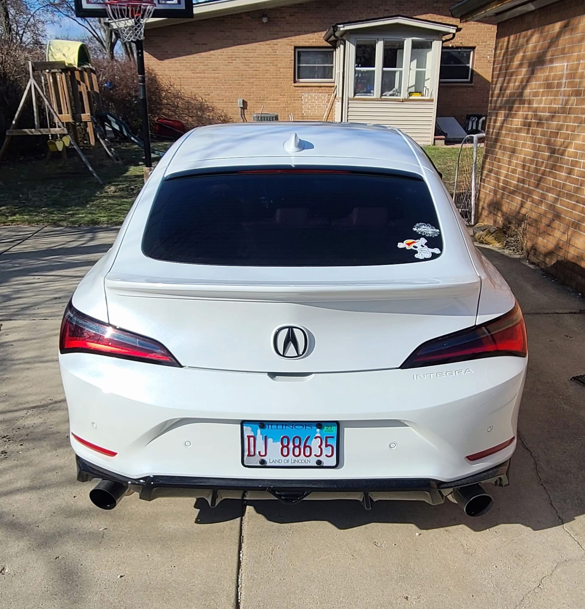 Rear-on view of a white Acura Integra showing the Epsilon+ rear trunk lip