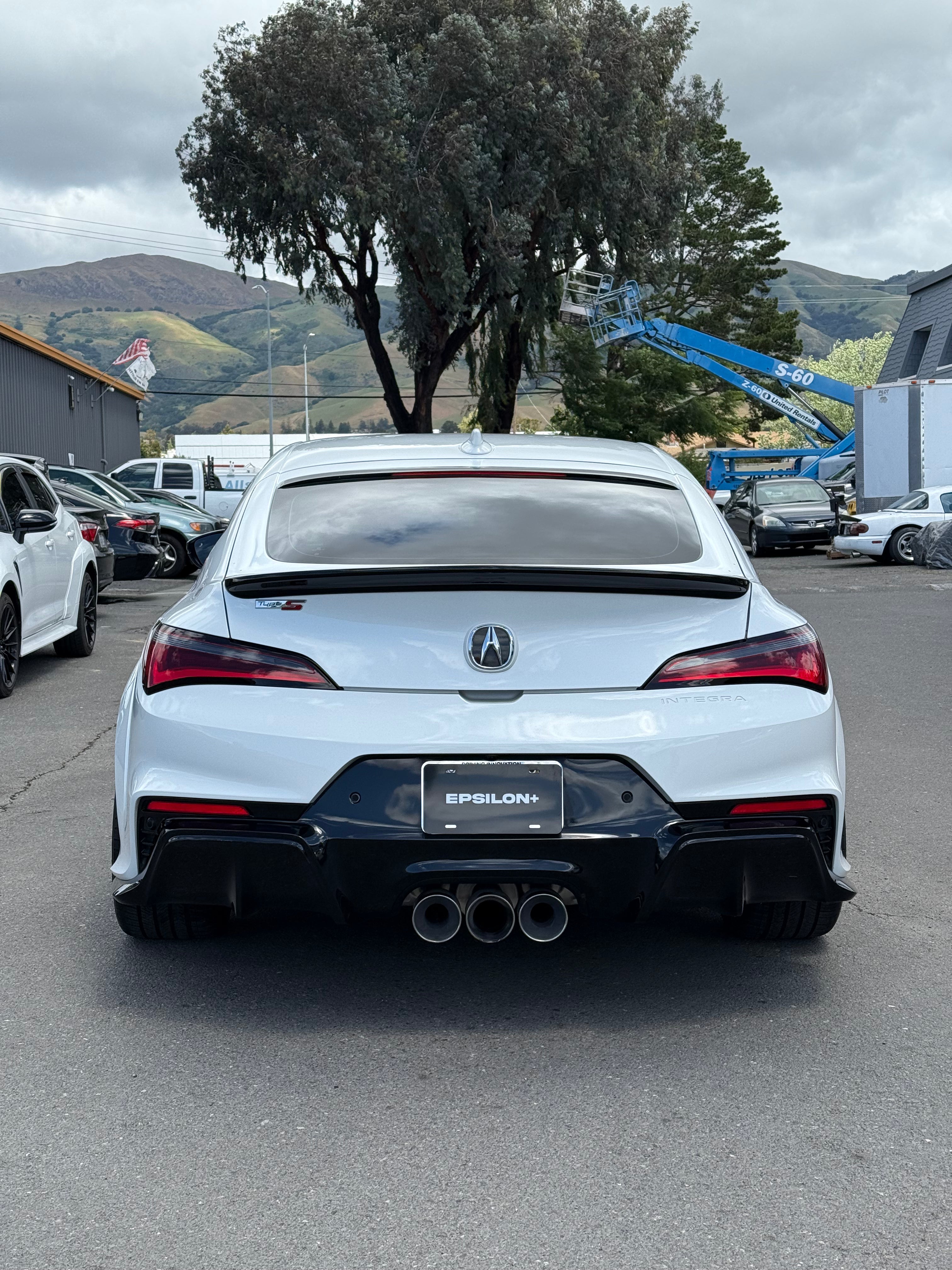 Rear view of a white Acura Integra with the Epsilon+ rear trunk lip and quad exhaust