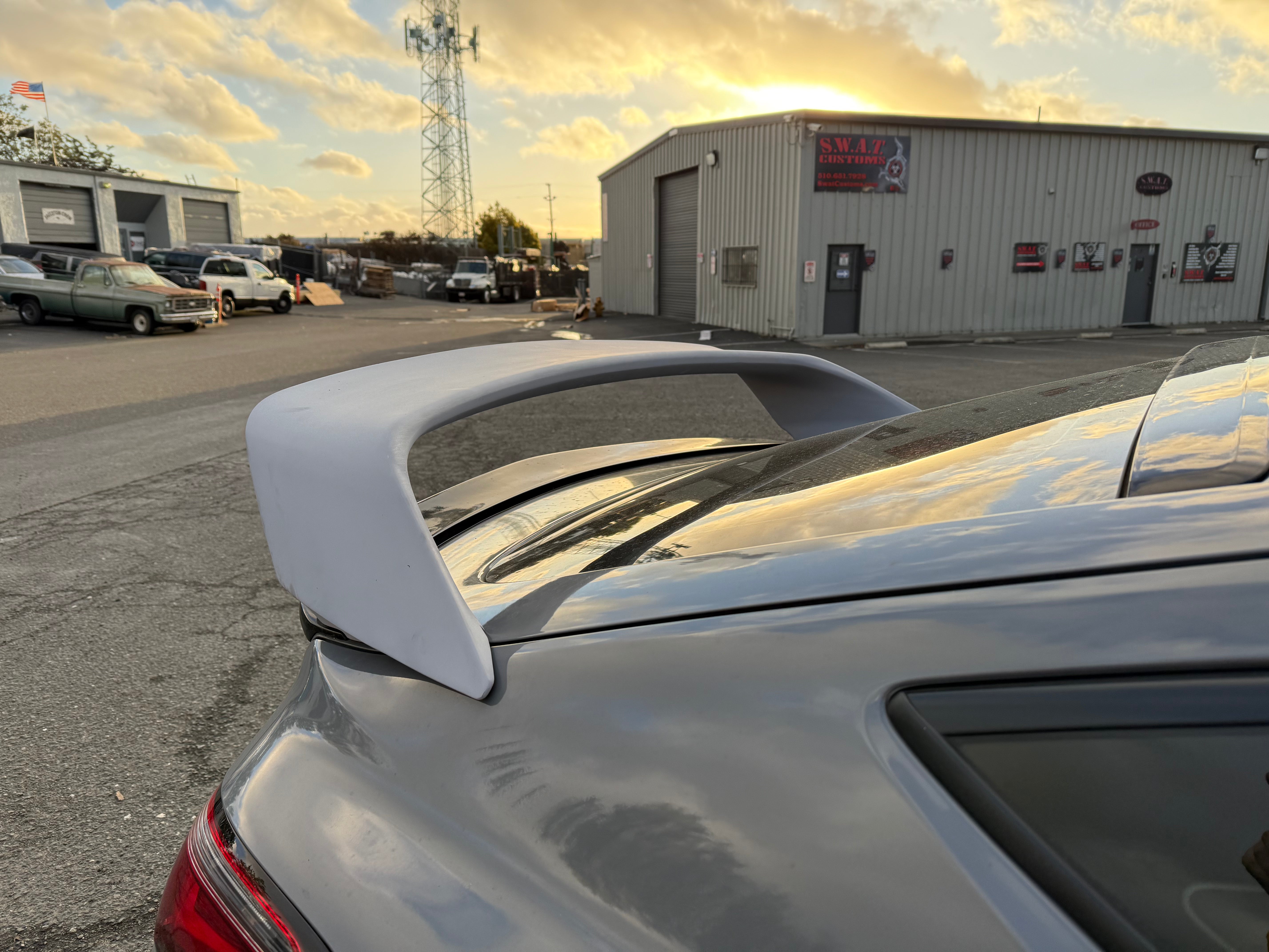 Close-up of the Sport Wing mounted on a silver Acura Integra trunk at sunset