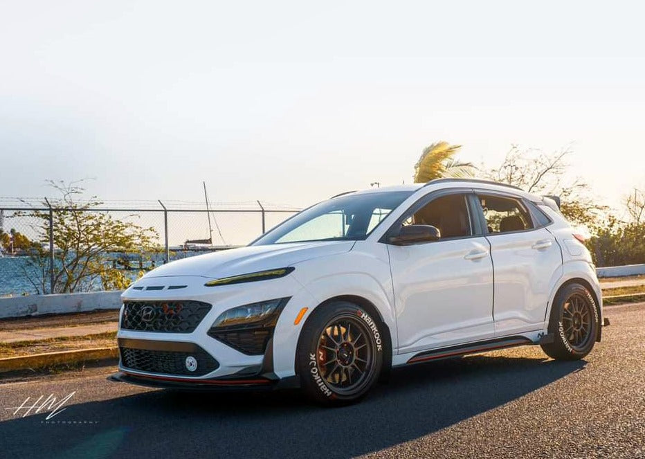 Side profile of a white Kona N with spoiler extension on gold wheels