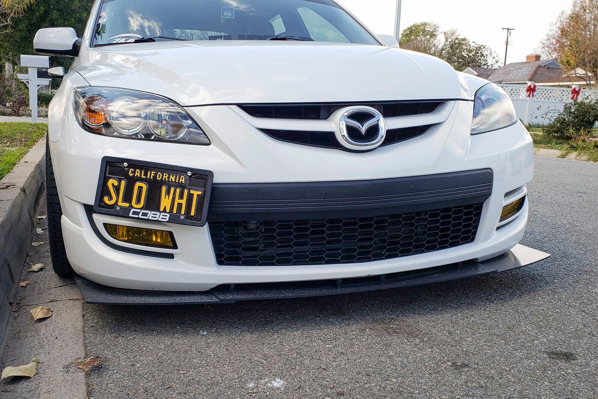 Front-on view of the Epsilon+ front lip mounted on a white Mazdaspeed3 Gen1