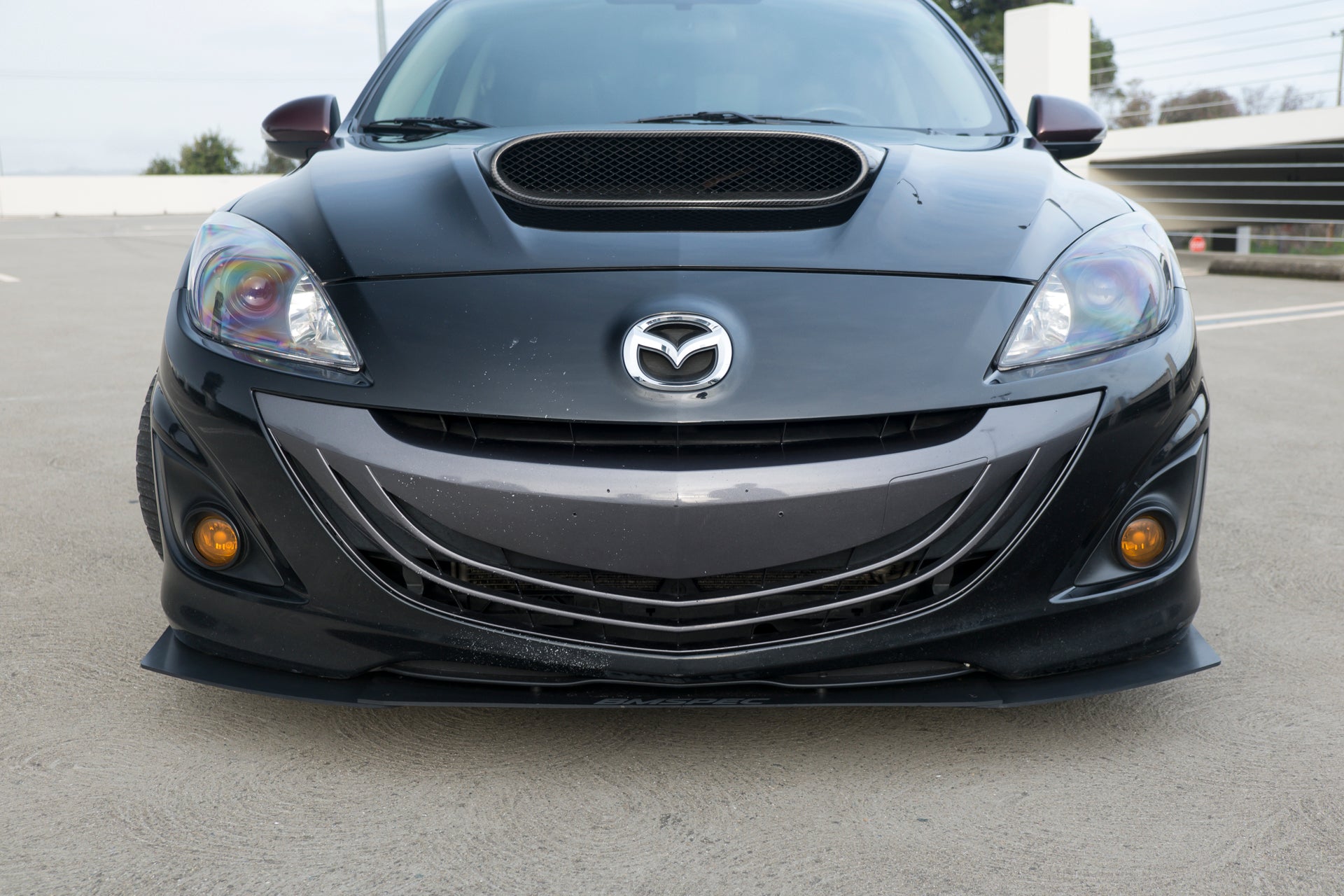 Front-on view of the Epsilon+ front lip mounted on a black Mazdaspeed3 Gen2