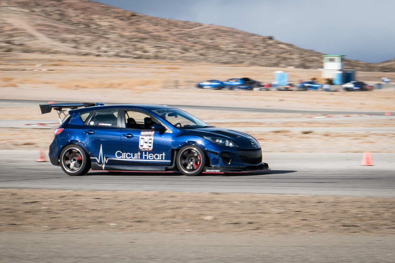 Blue Mazdaspeed3 Gen2 motorsport car with GT wing on a desert track