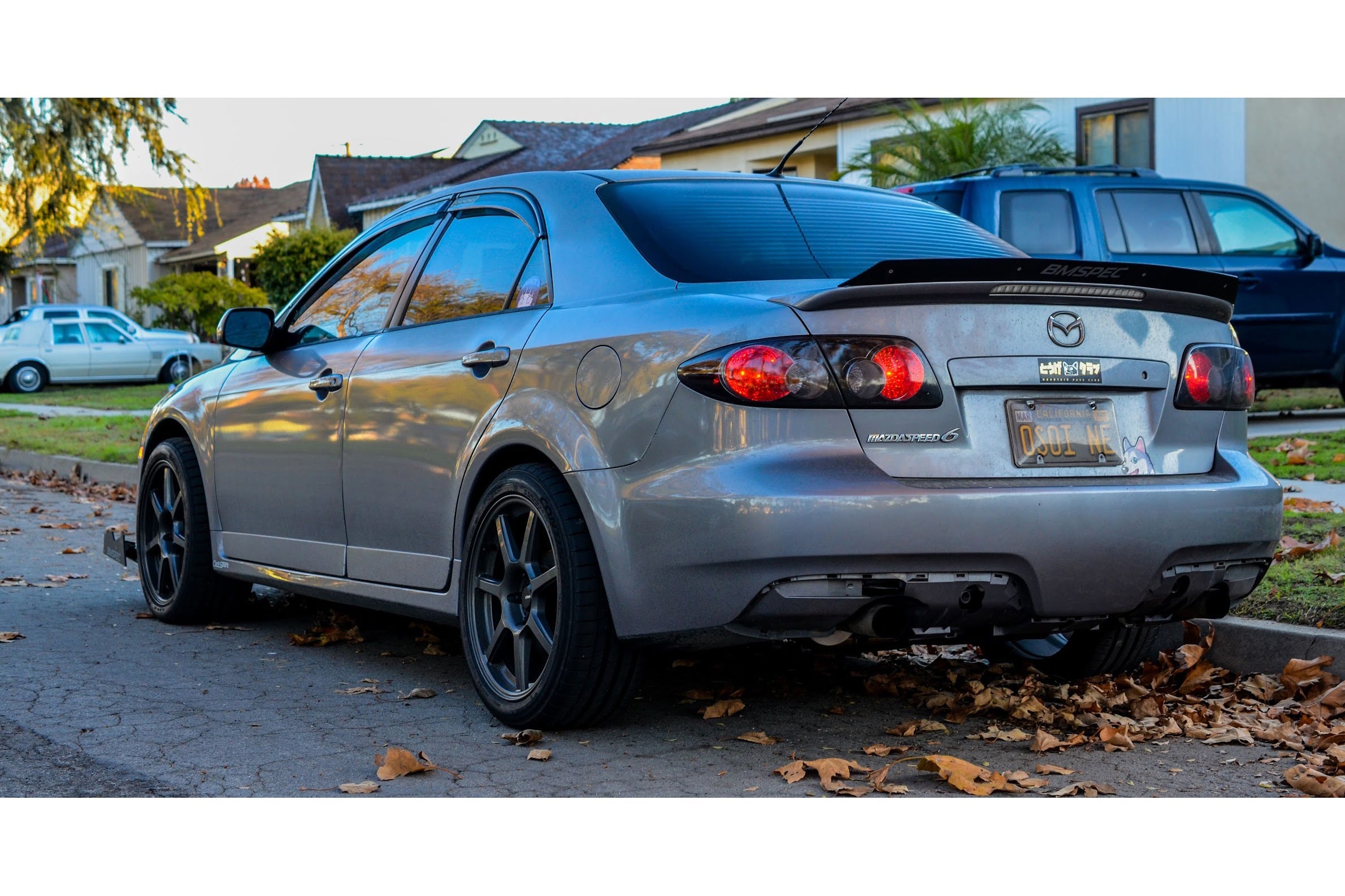 Rear three-quarter view of a silver Mazdaspeed6 with spoiler extension in a driveway
