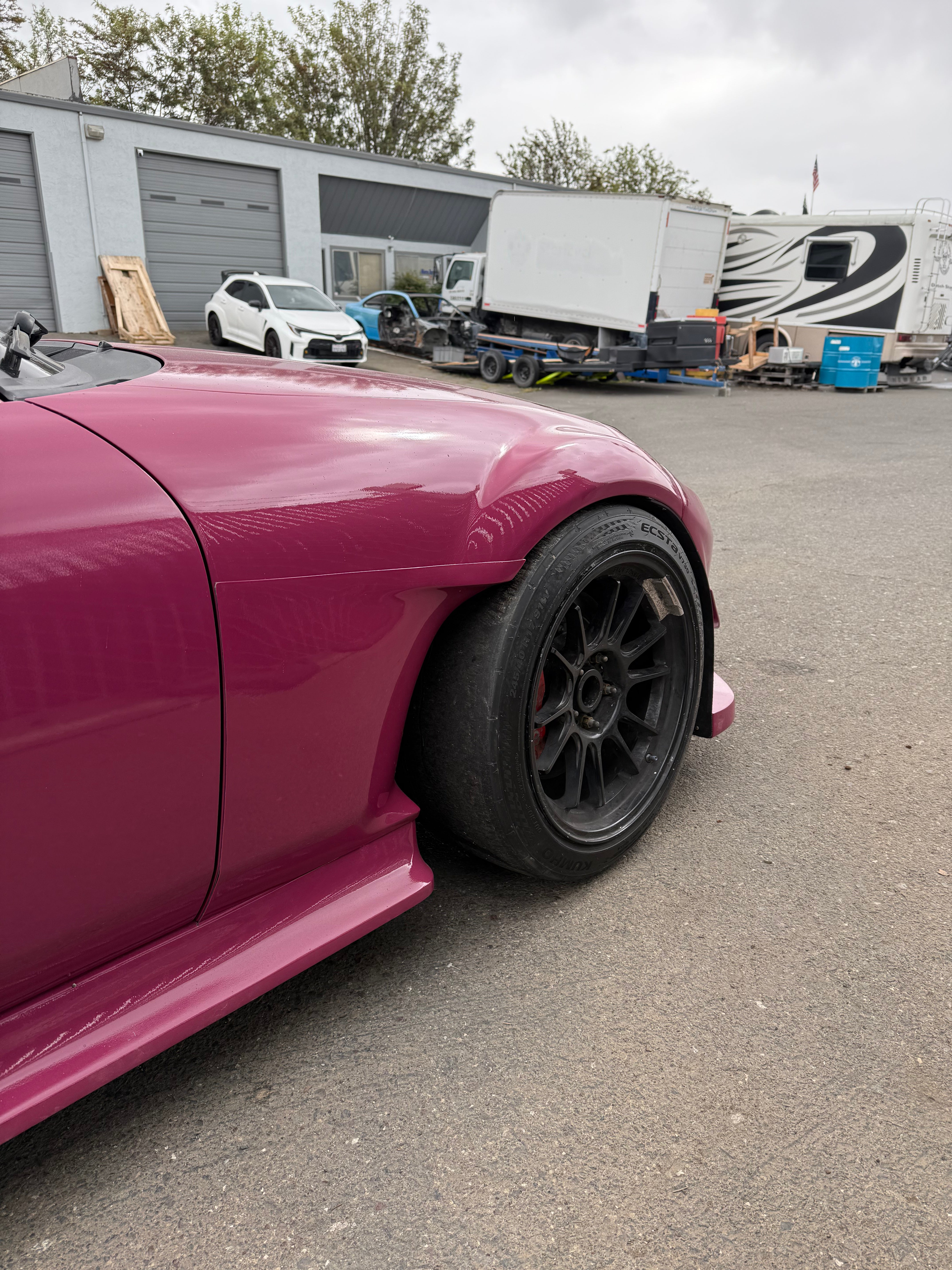 Side view of a pink Mazda MX-5 Miata NC with Epsilon+ fender cuts and side skirts