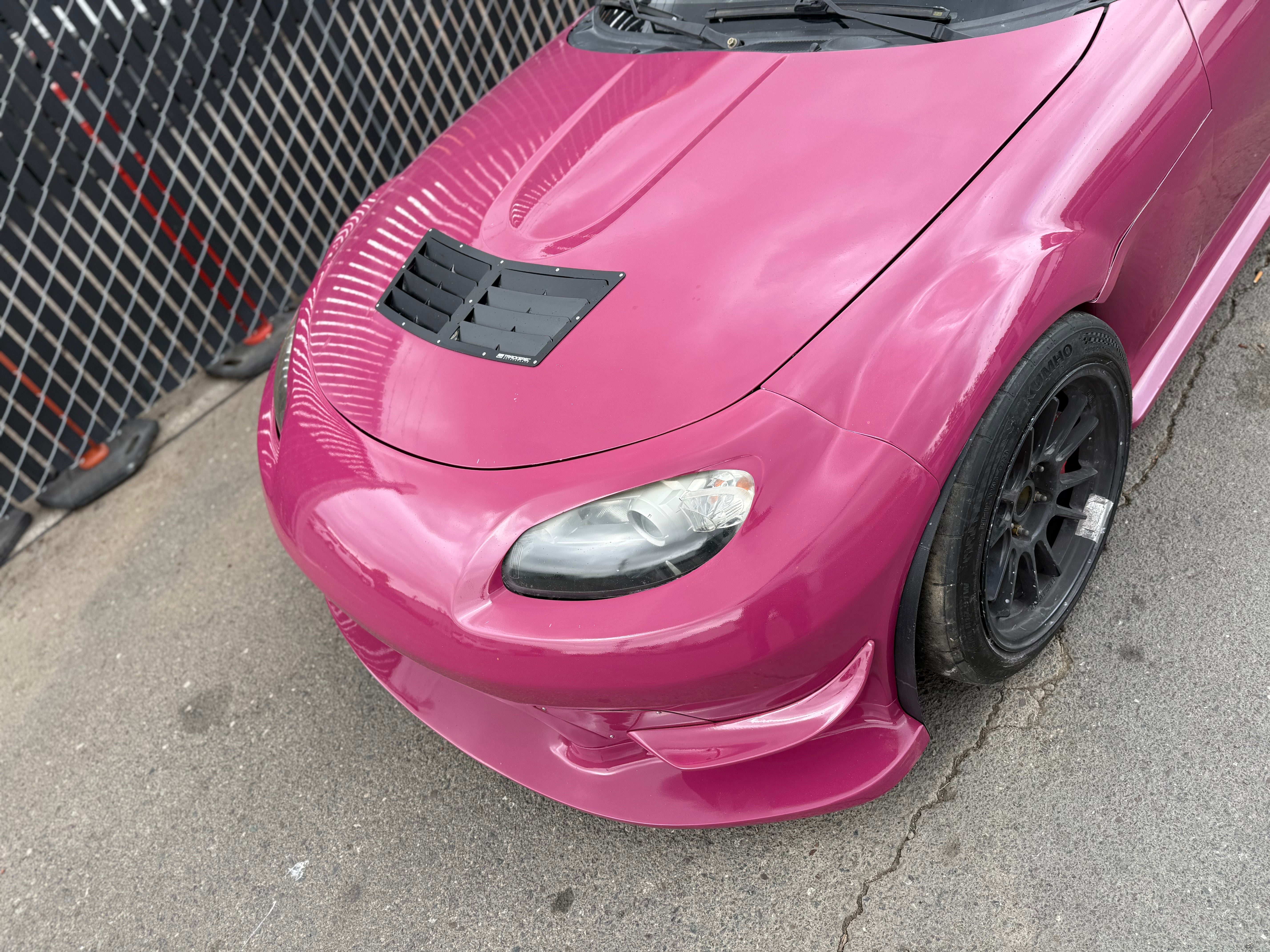Low front corner view of the Epsilon+ front bumper on a pink Miata NC