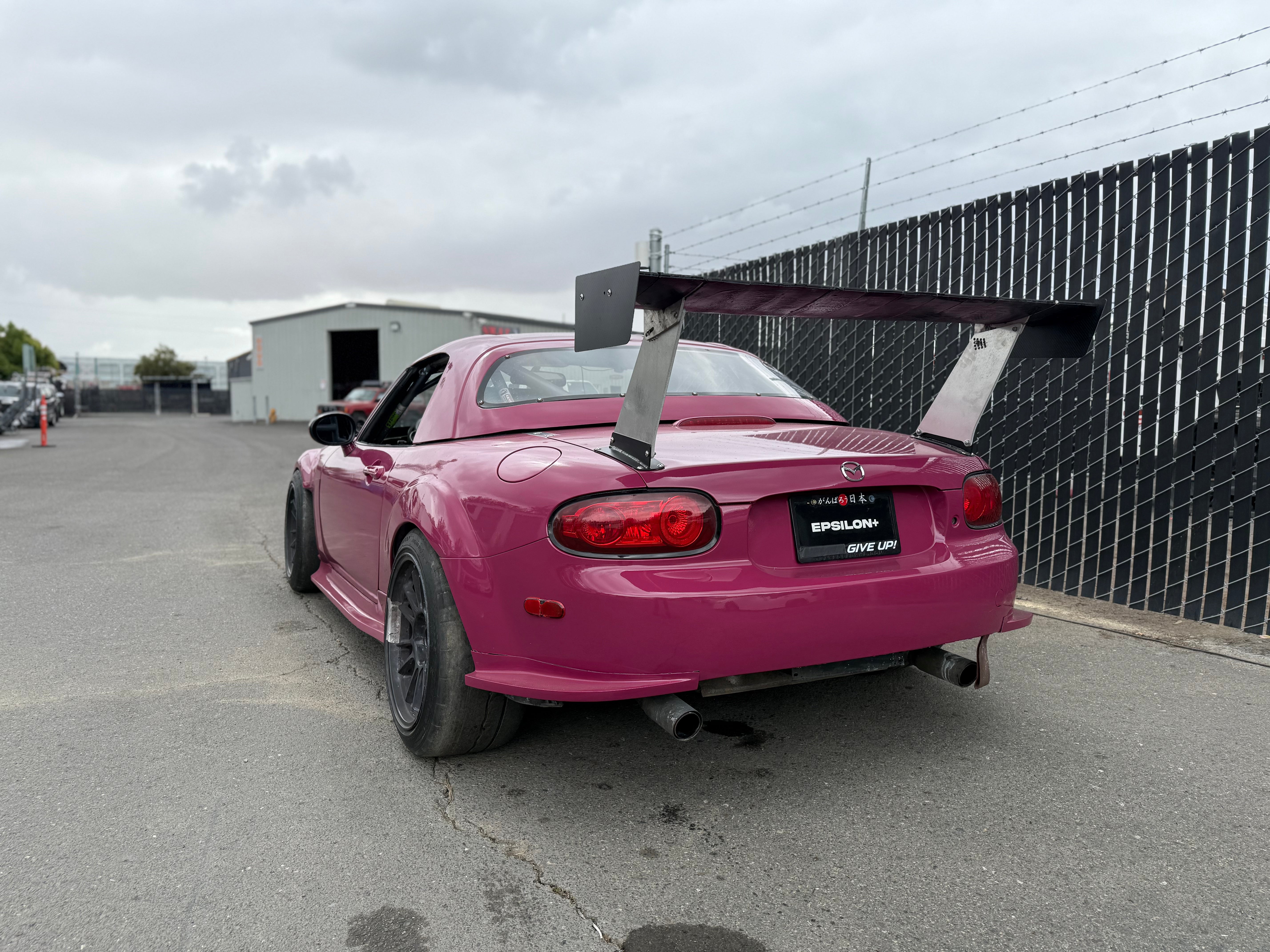 Rear three-quarter view of a pink Mazda MX-5 Miata NC1 with Epsilon+ rear spats