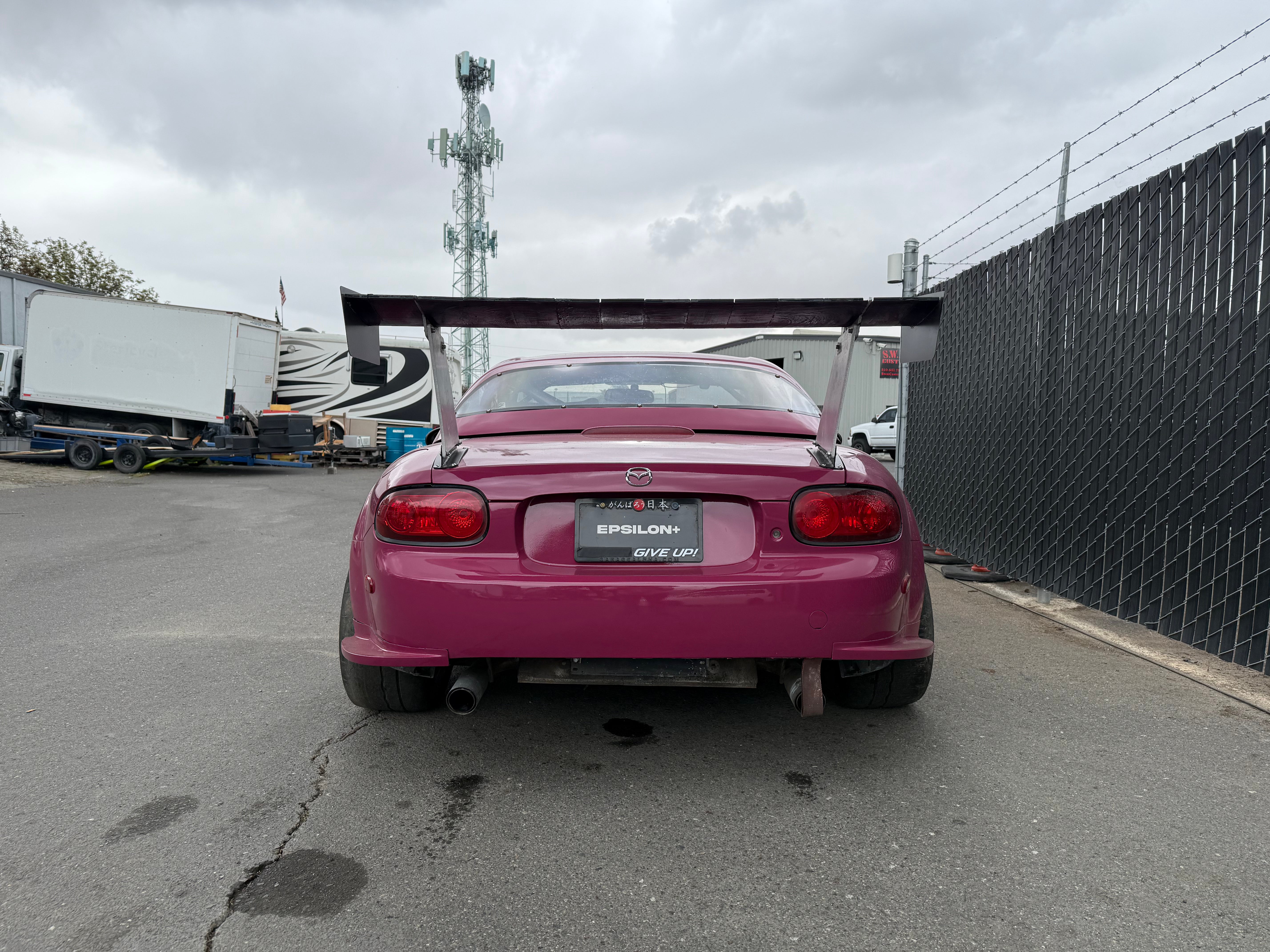 Close rear view of a pink Mazda MX-5 Miata NC1 with rear spats fitted