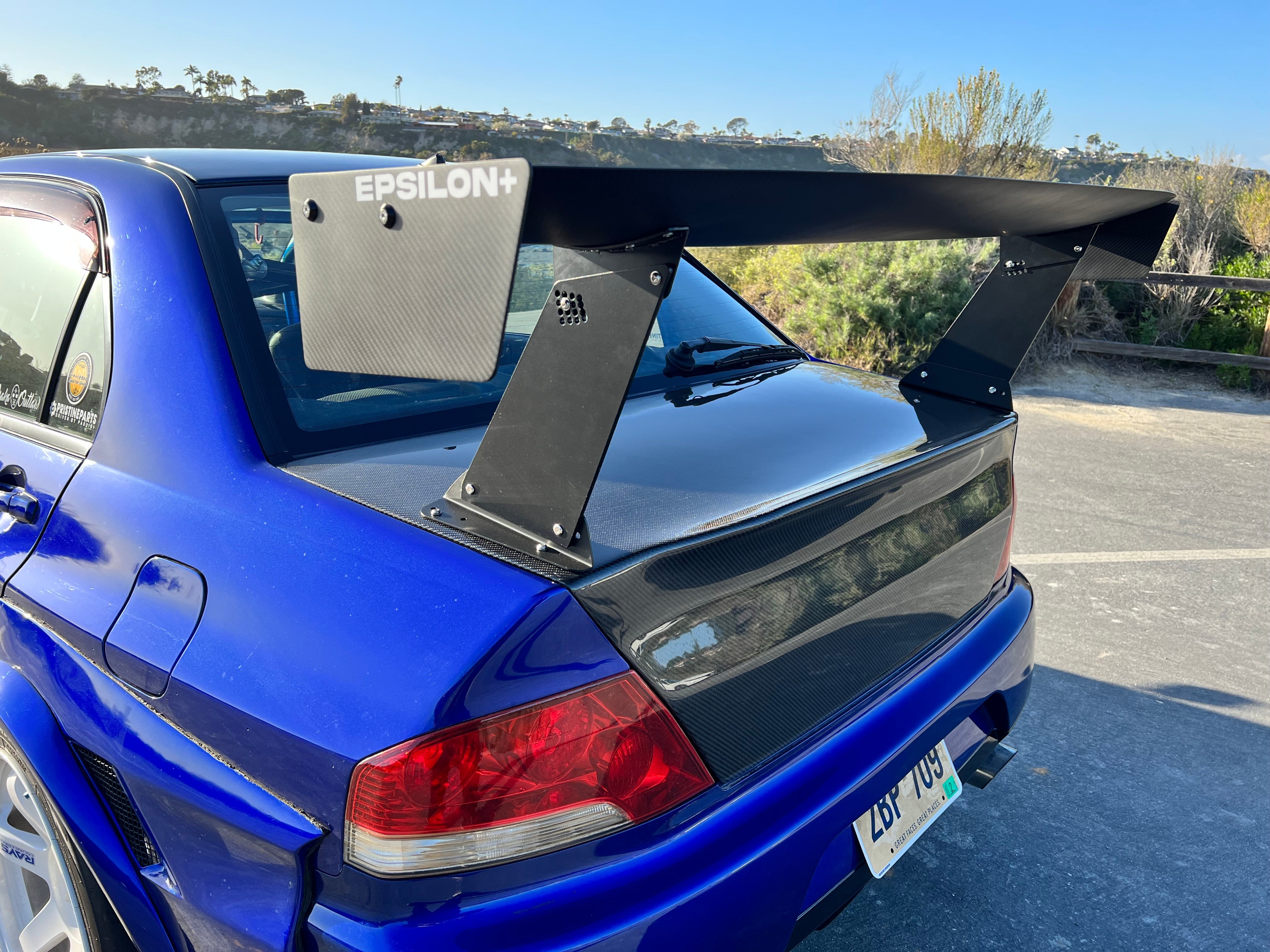 Rear three-quarter close-up of the GT wing endplate on a blue Mitsubishi Evo