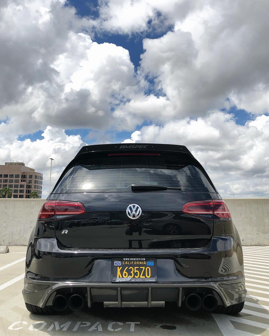 Rear view of a black Volkswagen Golf R with spoiler extension on the trunk wing