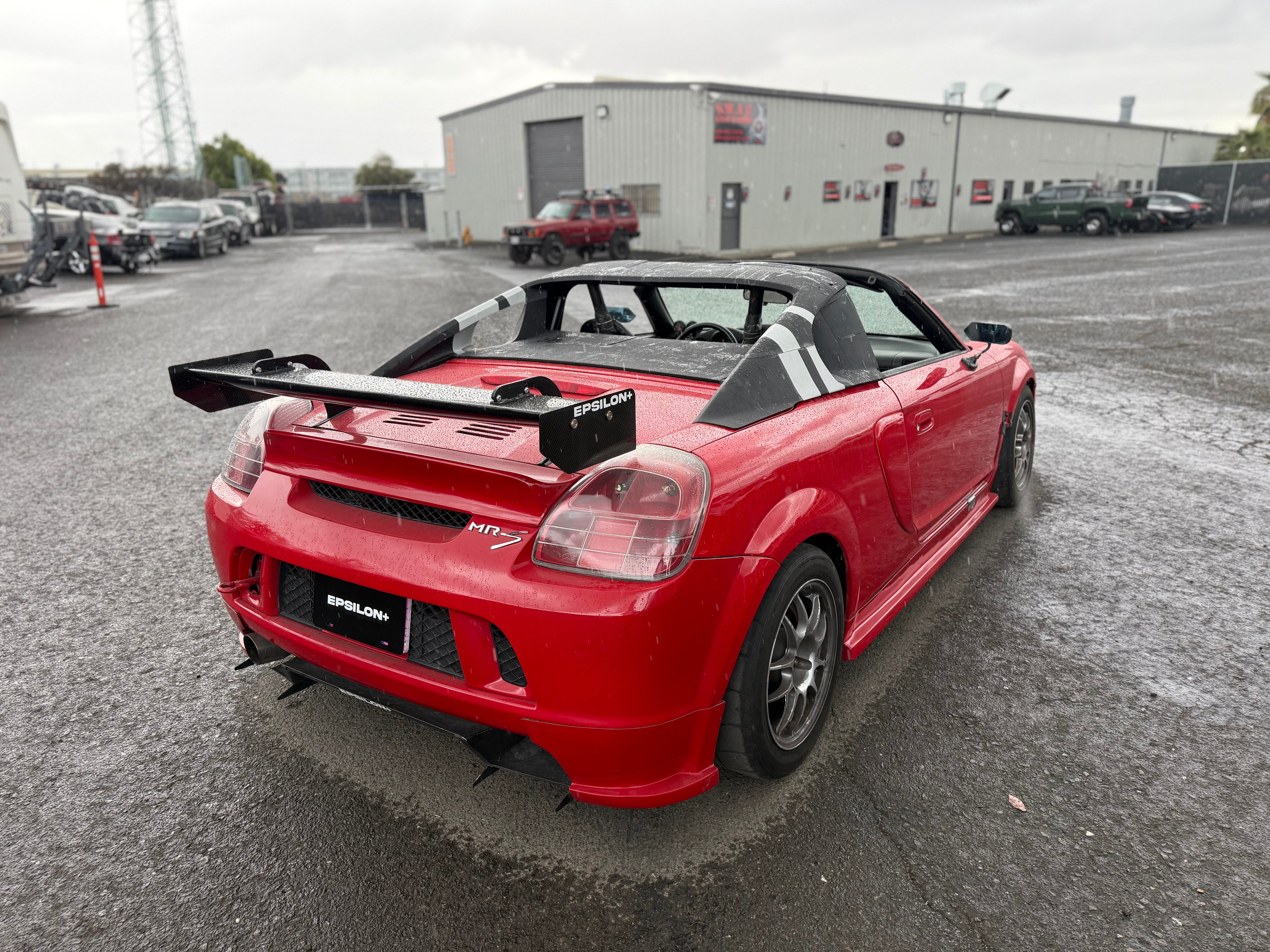 Rear view of a red Toyota MR2 Spyder with rear wing and diffuser
