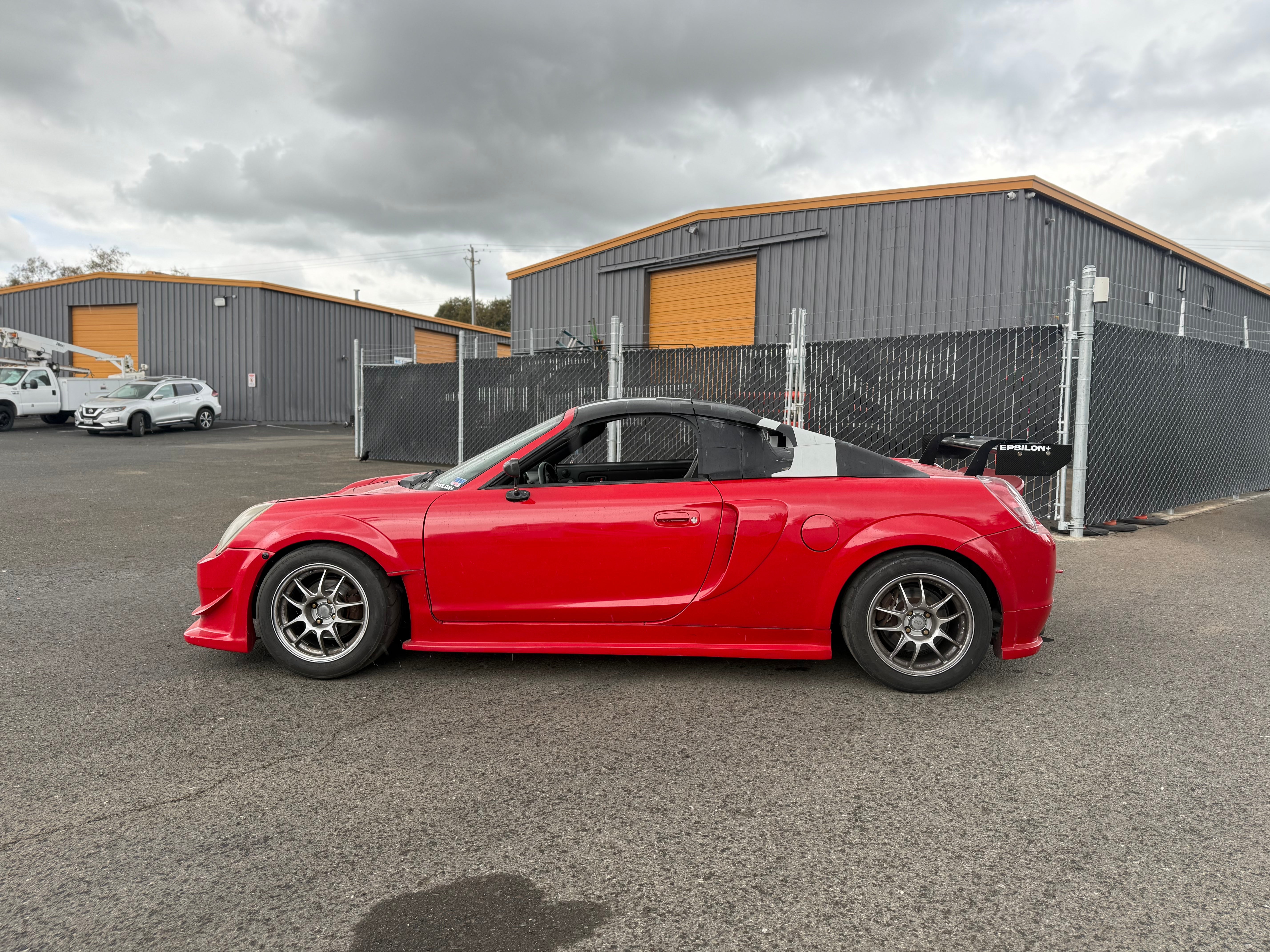 Side view of a red Toyota MR2 Spyder showing the roofline and side skirts